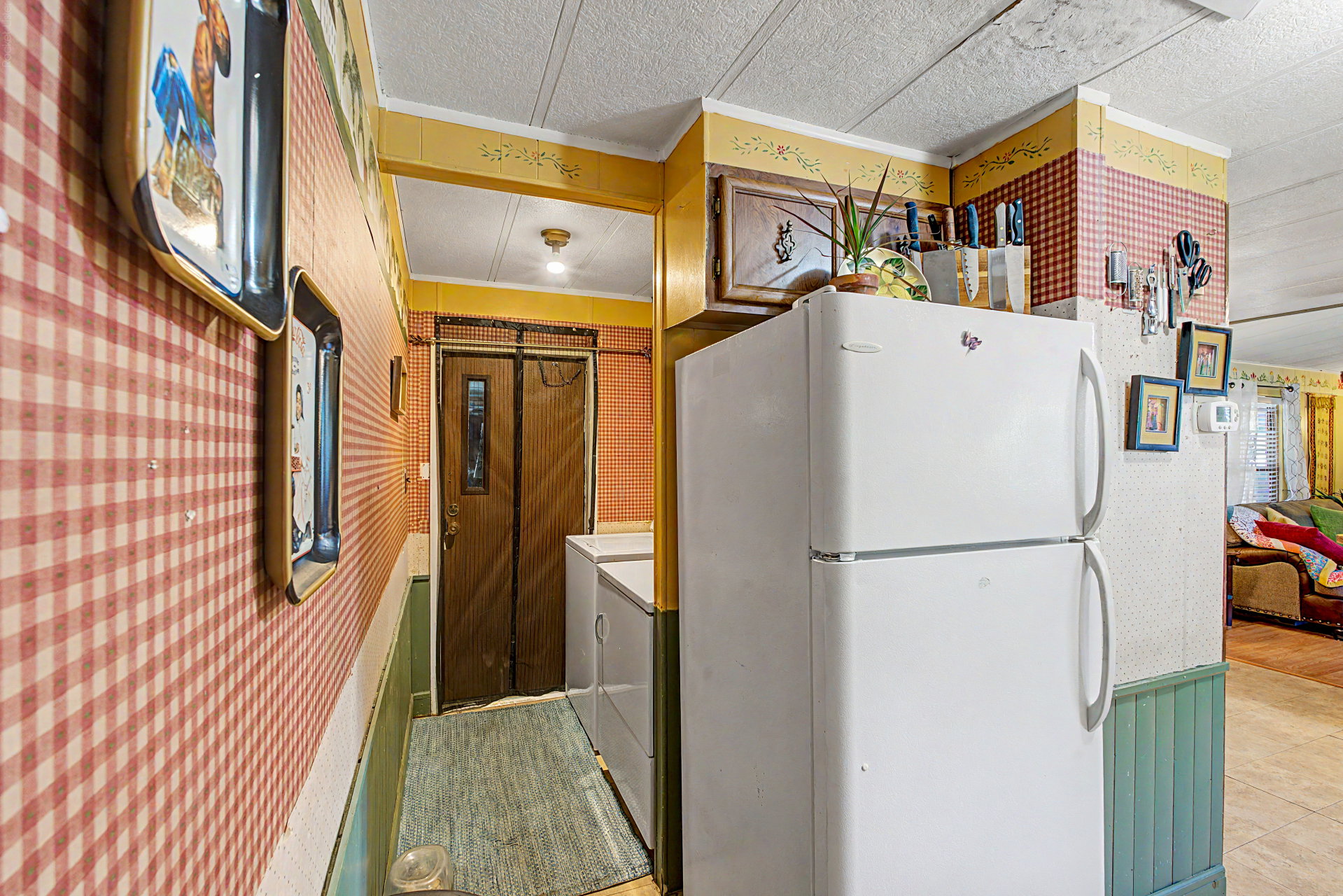 Kitchen area featuring a two-door refrigerator, built-in cabinetry, and a patterned wallpaper design