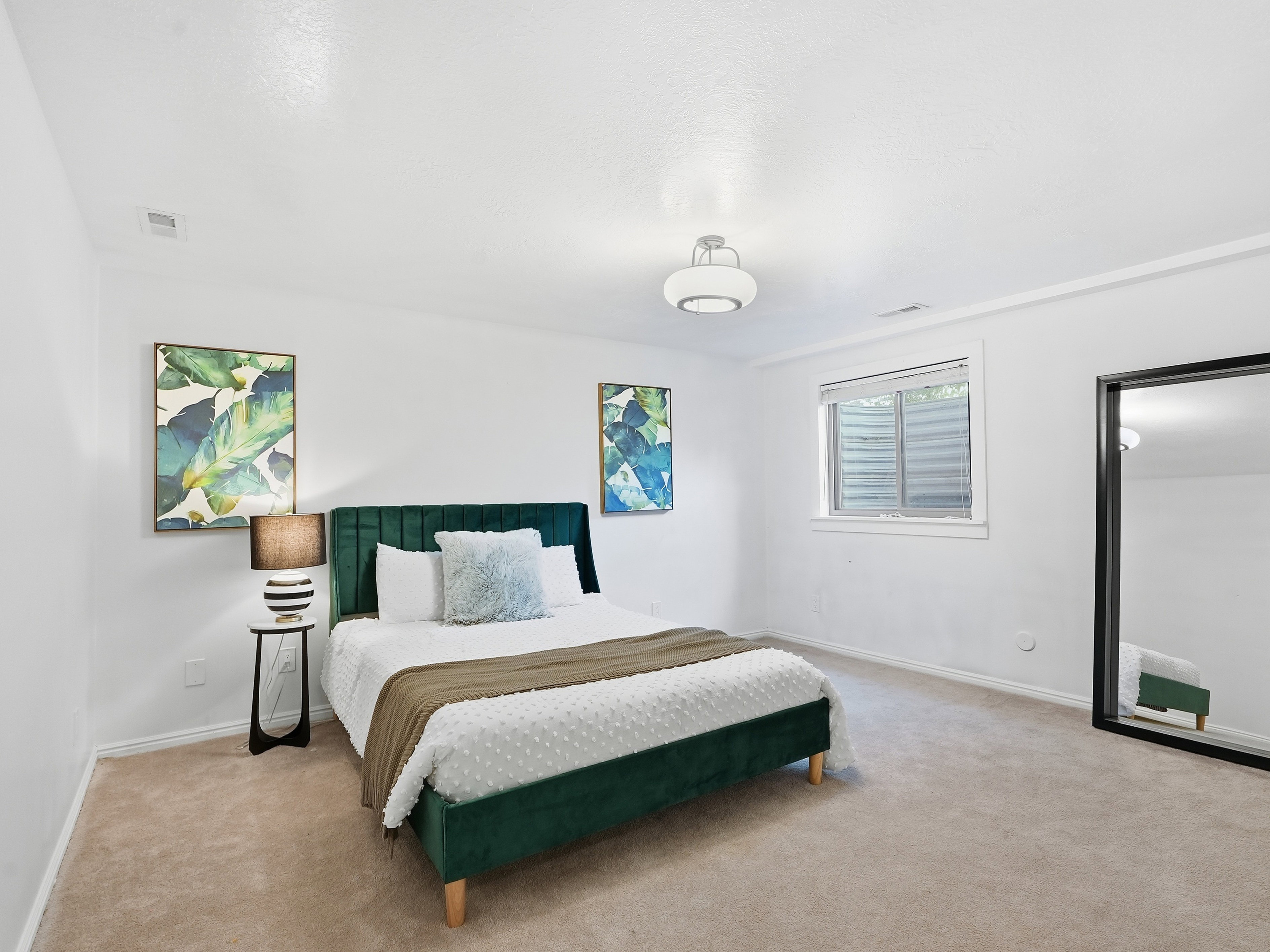 Carpeted room with white walls, a single window with horizontal blinds, and a flush-mount ceiling light fixture