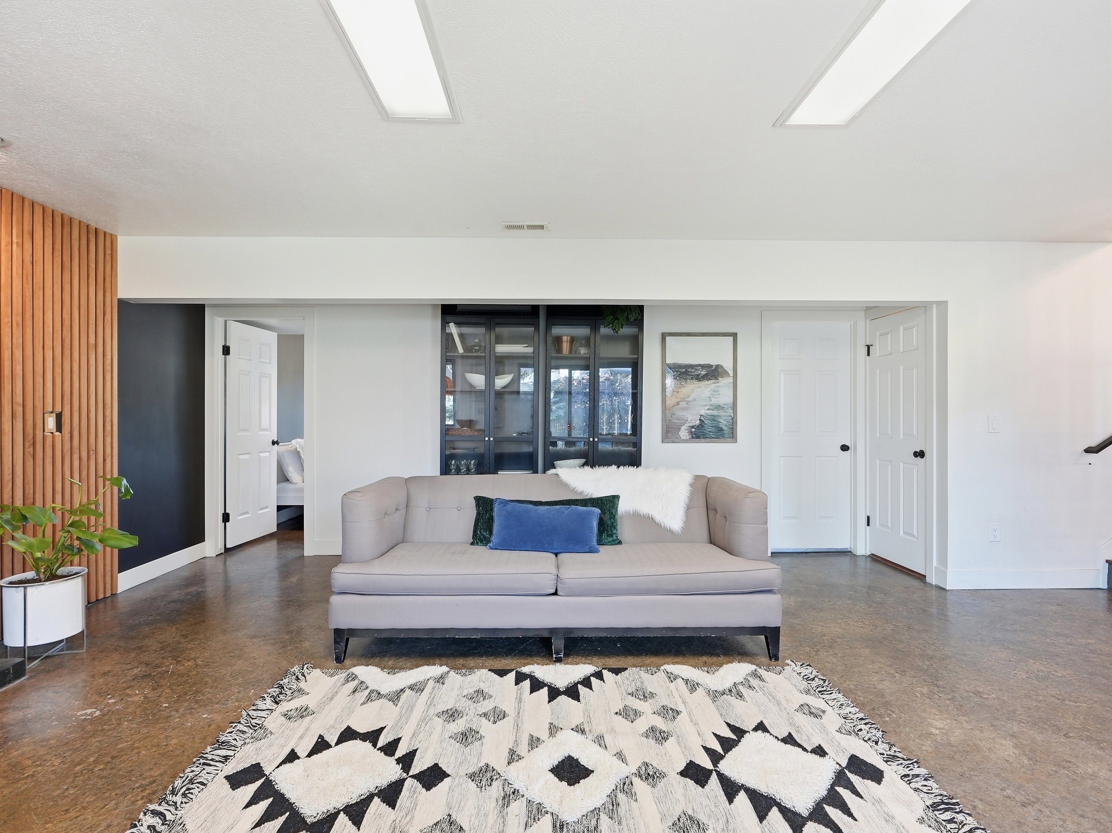 Spacious room featuring concrete flooring, recessed ceiling lighting, and a modern wood slat accent wall