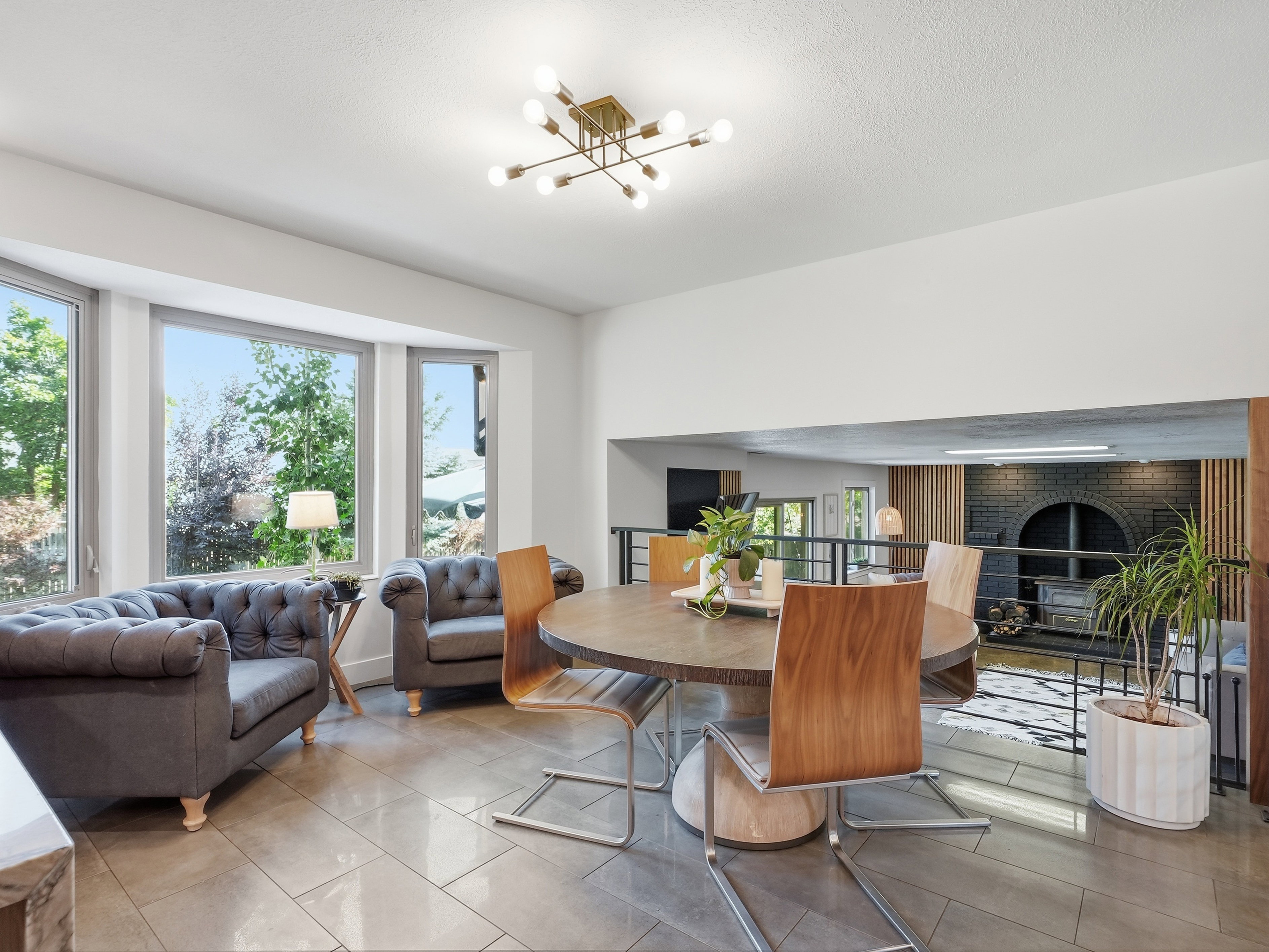 Dining area featuring a contemporary chandelier, tile flooring, and a bay window