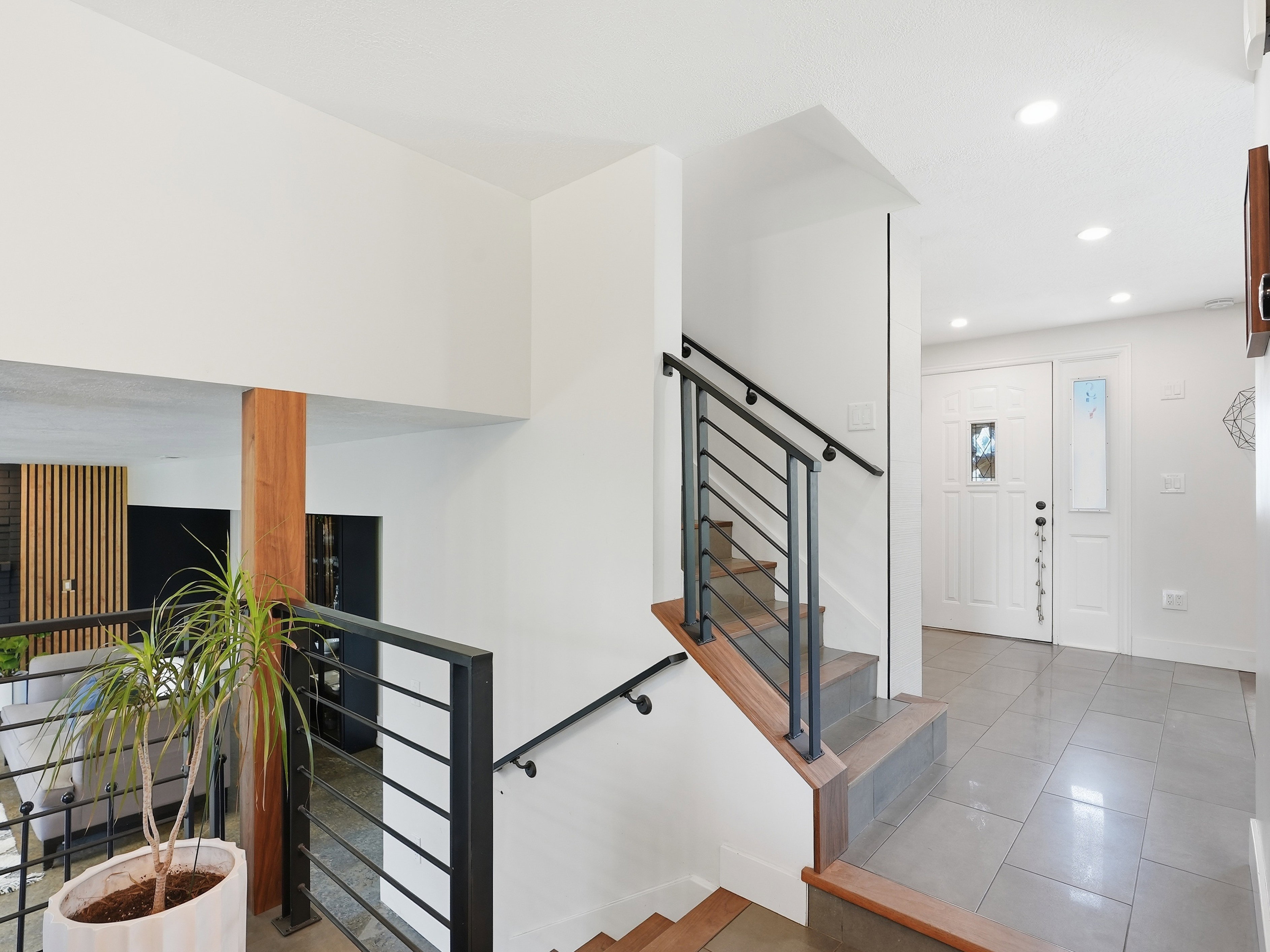 Foyer featuring a white entry door with frosted glass insert and sidelight, gray tile flooring, and recessed lighting