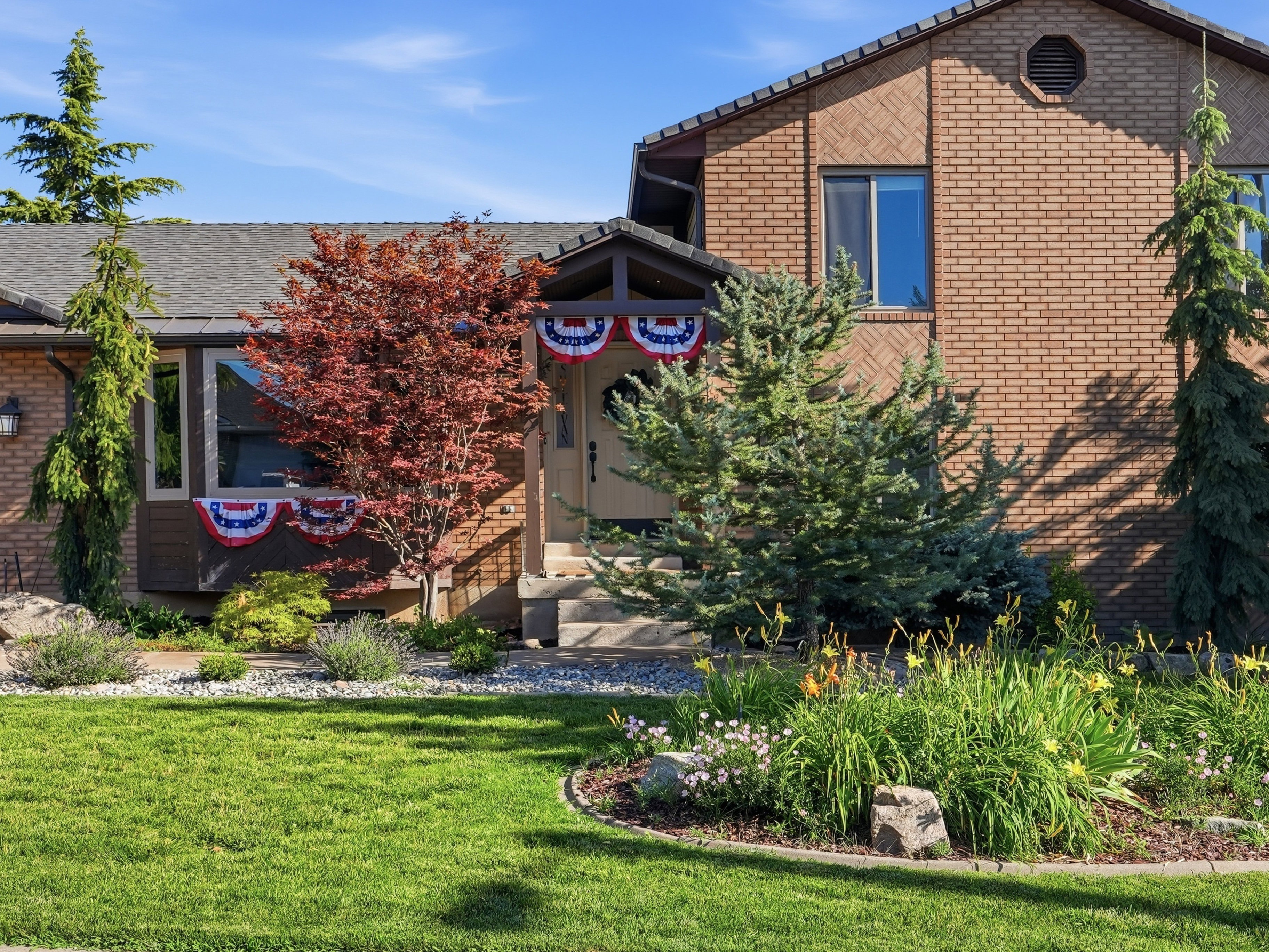 Brick exterior with a prominent entry porch and multiple windows