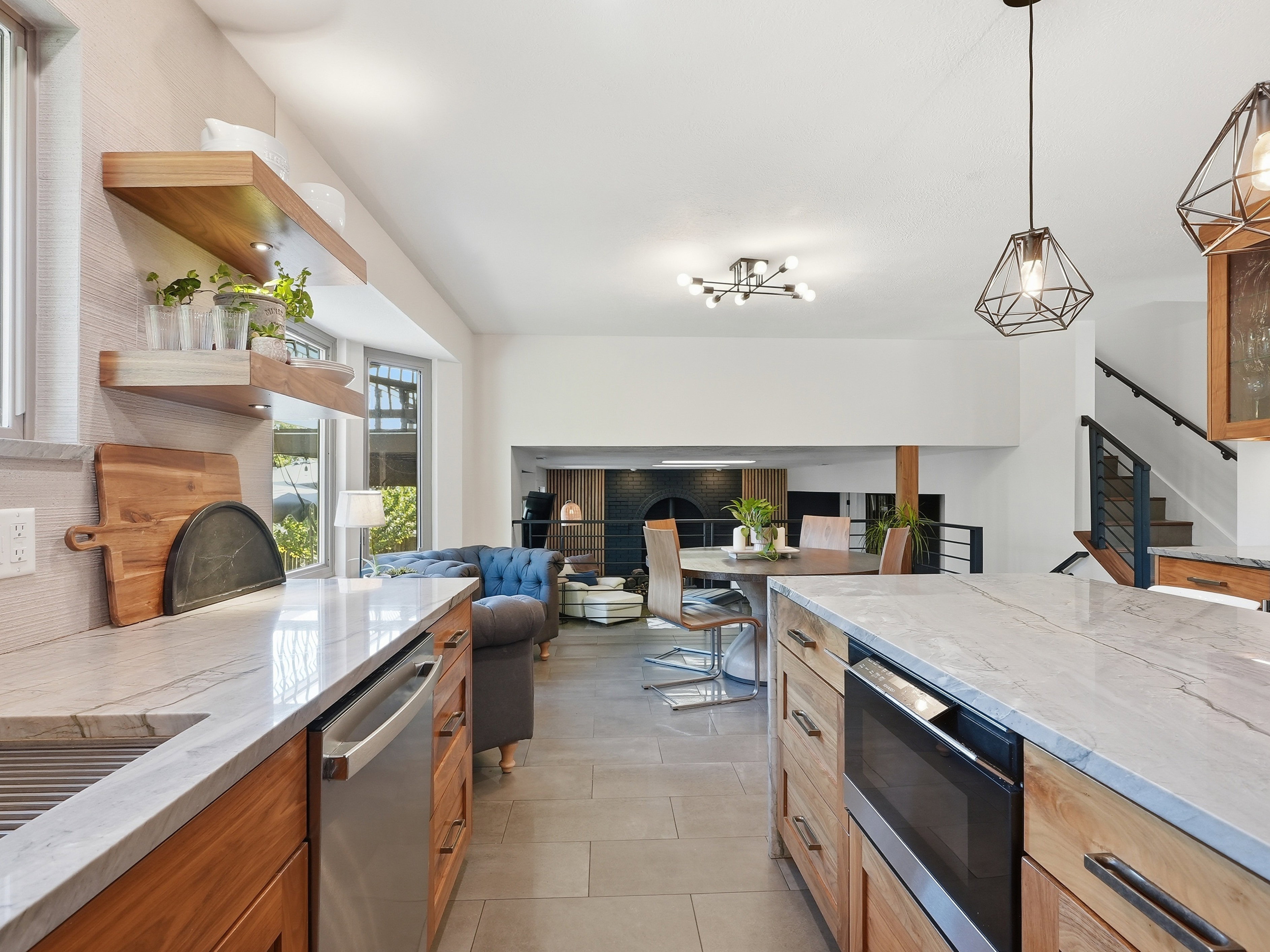 Kitchen area featuring light wood cabinetry, stone countertops, and integrated stainless steel appliances