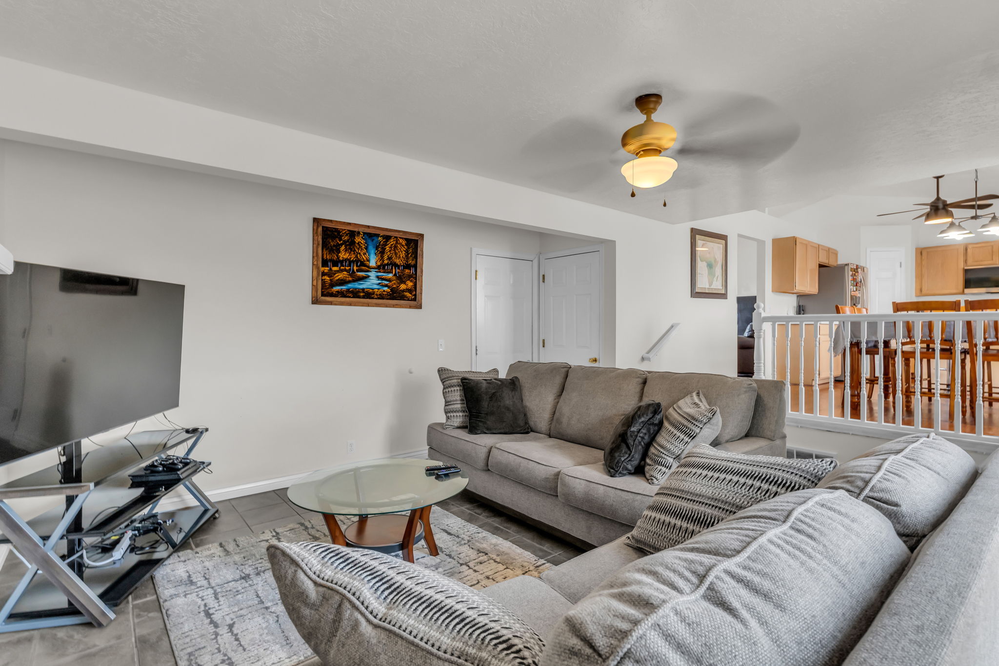 Expansive living area featuring tile flooring and a ceiling fan