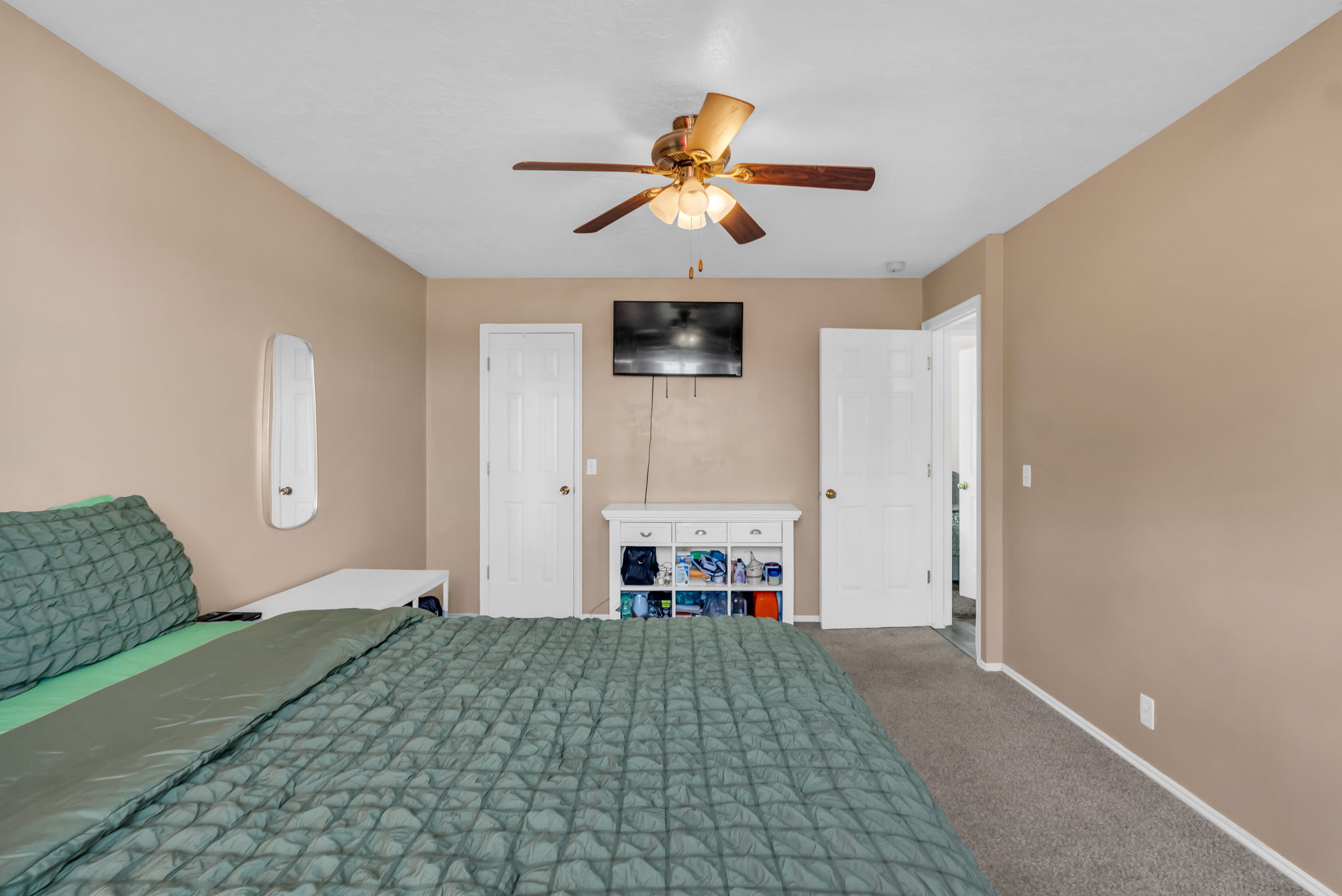 Bedroom featuring a ceiling fan, neutral wall tones, and plush carpeting