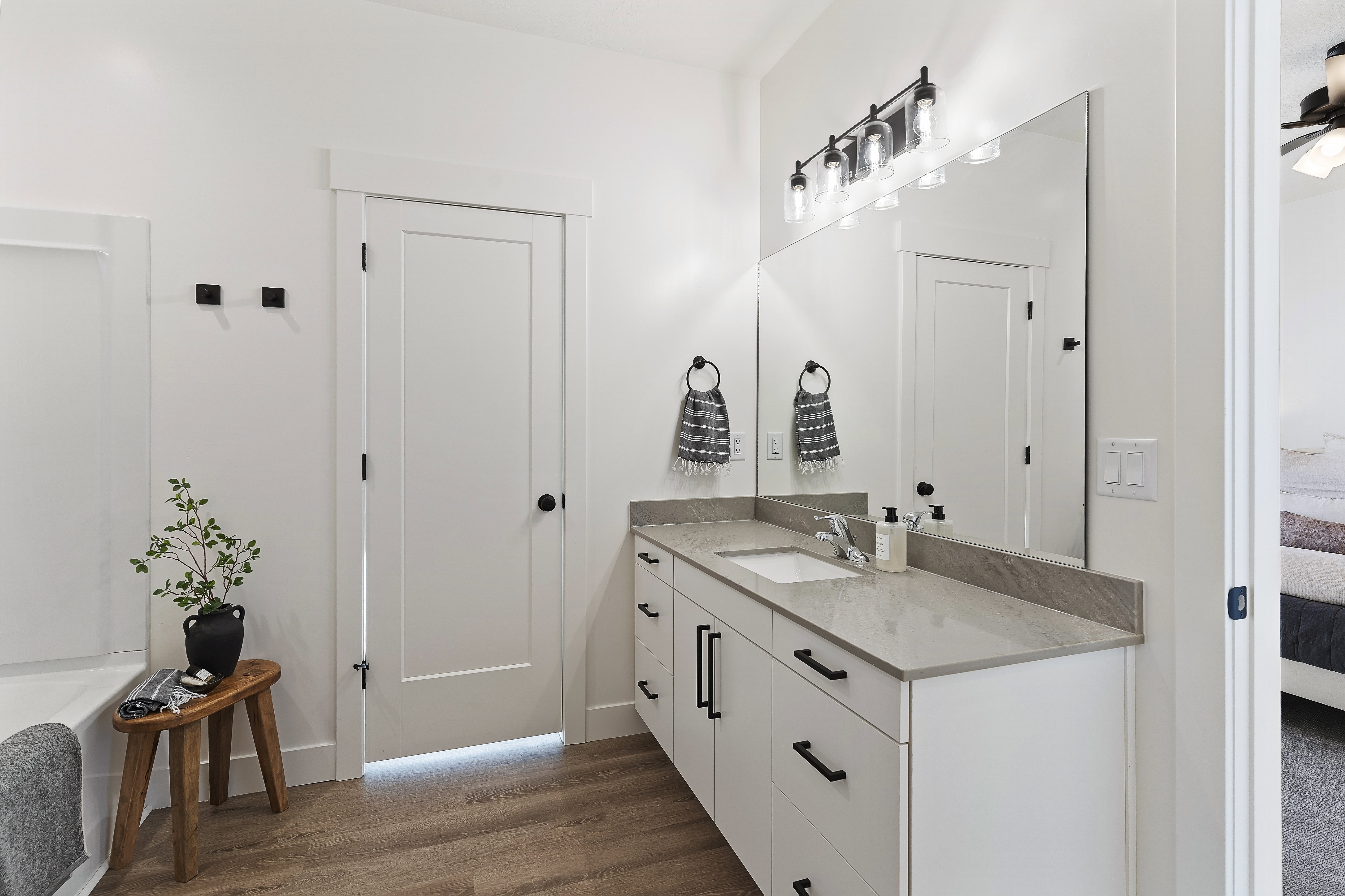 Bathroom featuring a spacious vanity with a single basin, light-toned countertop, and white cabinetry