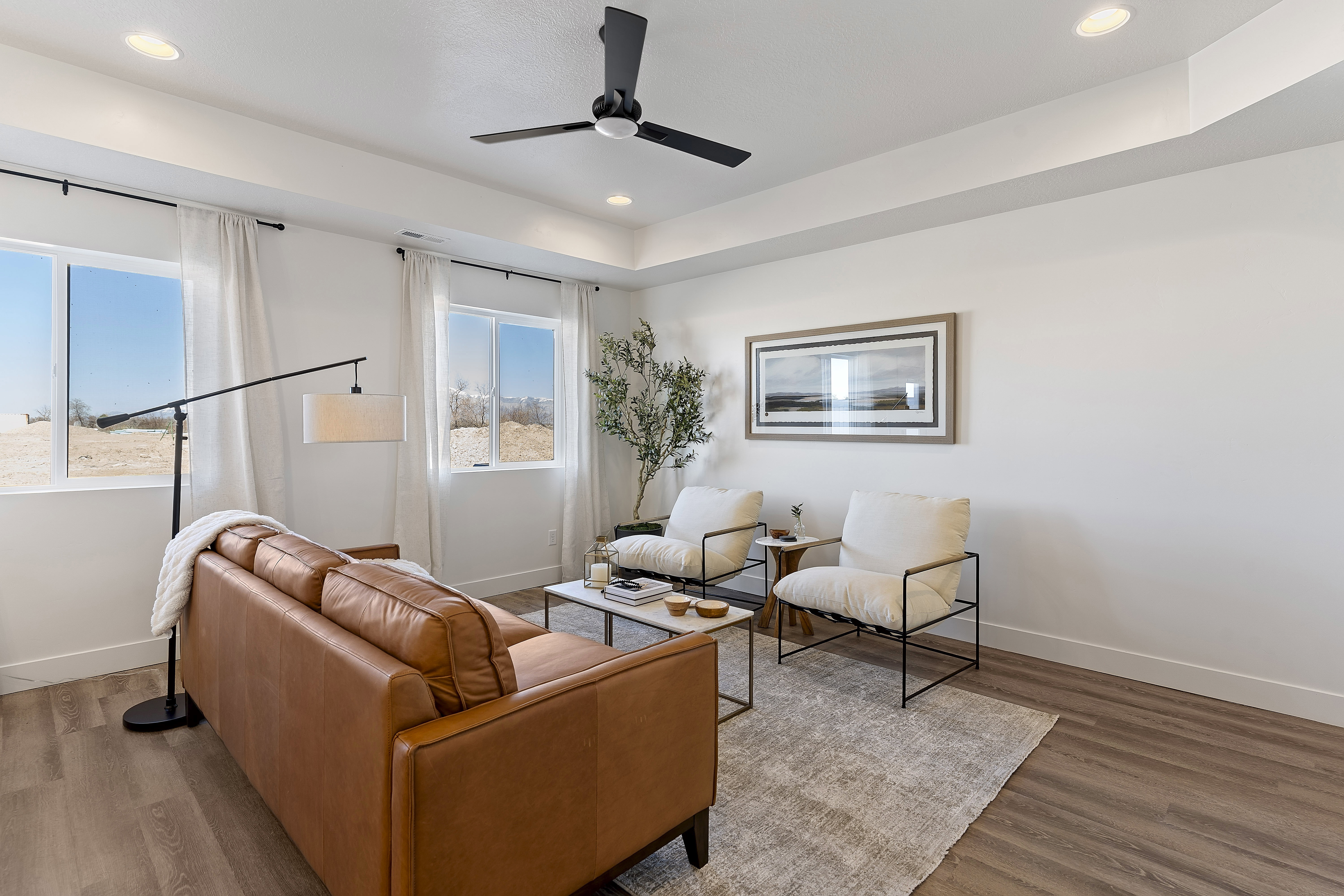 Bright living area featuring wood-finish flooring, recessed lighting, and a contemporary ceiling fan