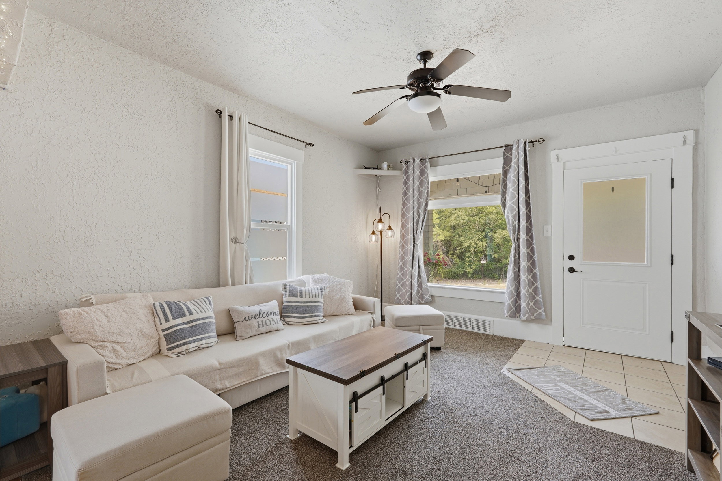 Living area featuring neutral wall tones and dark carpet flooring