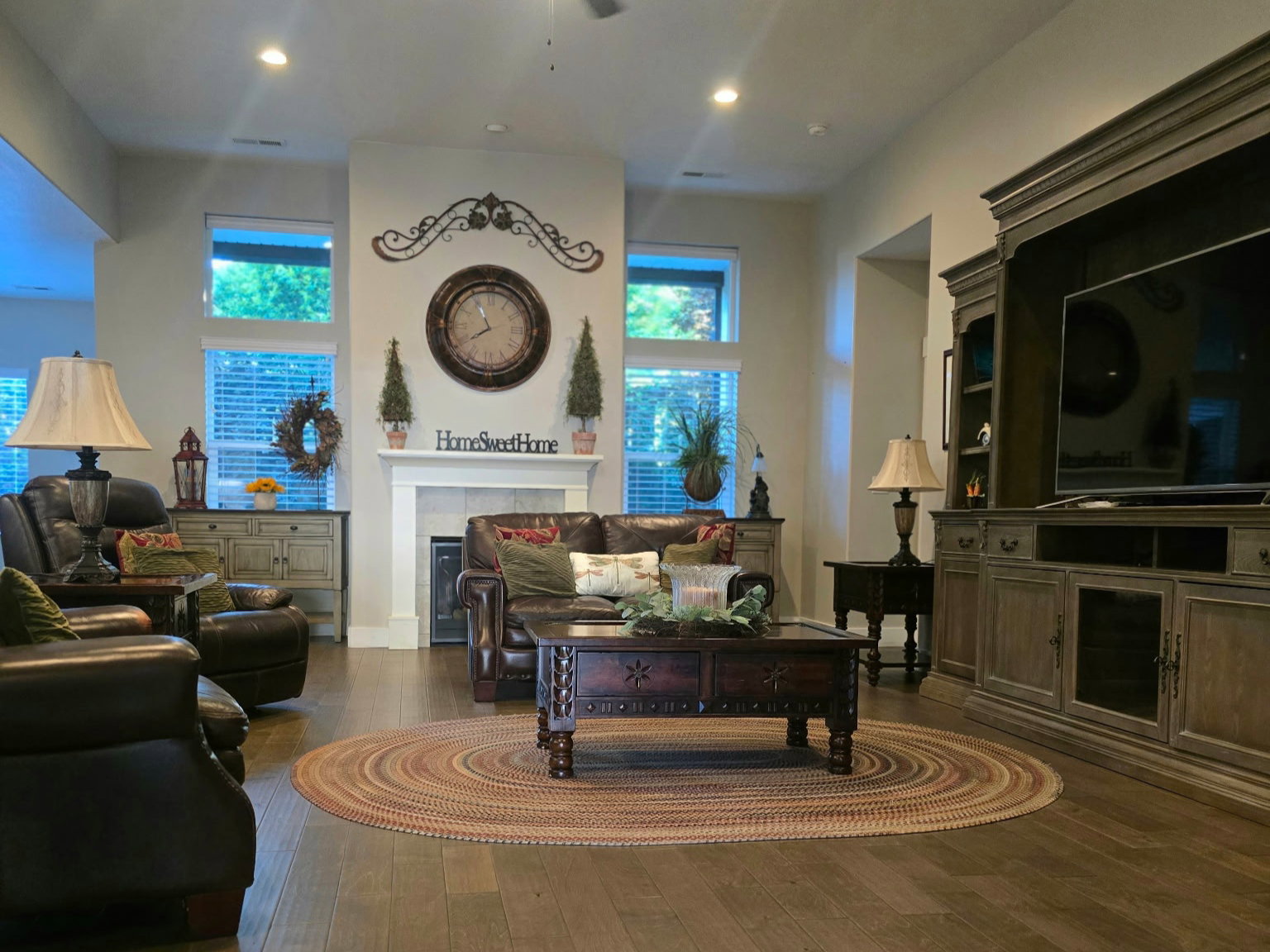 Spacious living area featuring wood-finish flooring, a ceiling fan, and recessed lighting