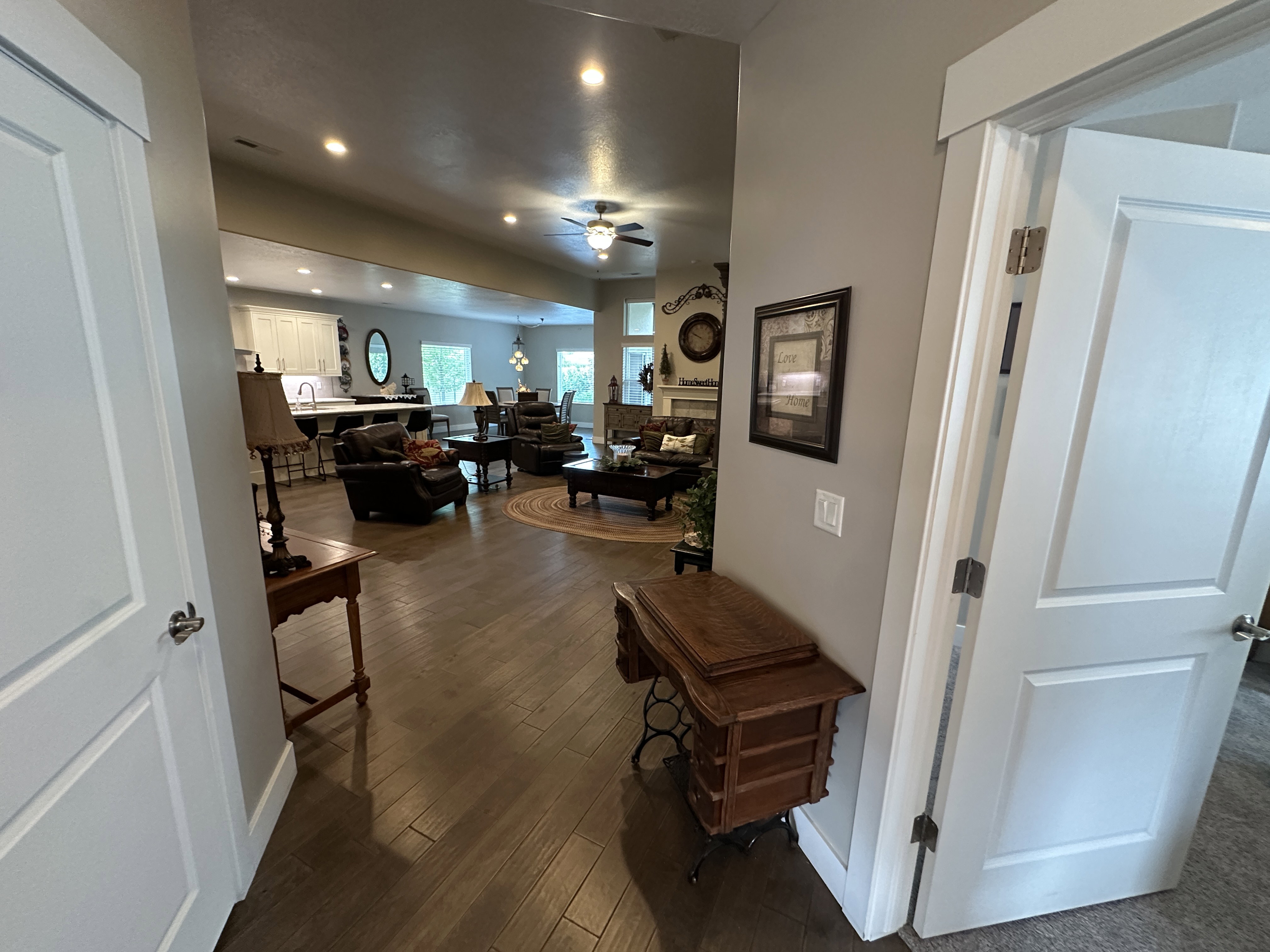 Open concept living space with recessed lighting, wood-finish flooring, and white trim details