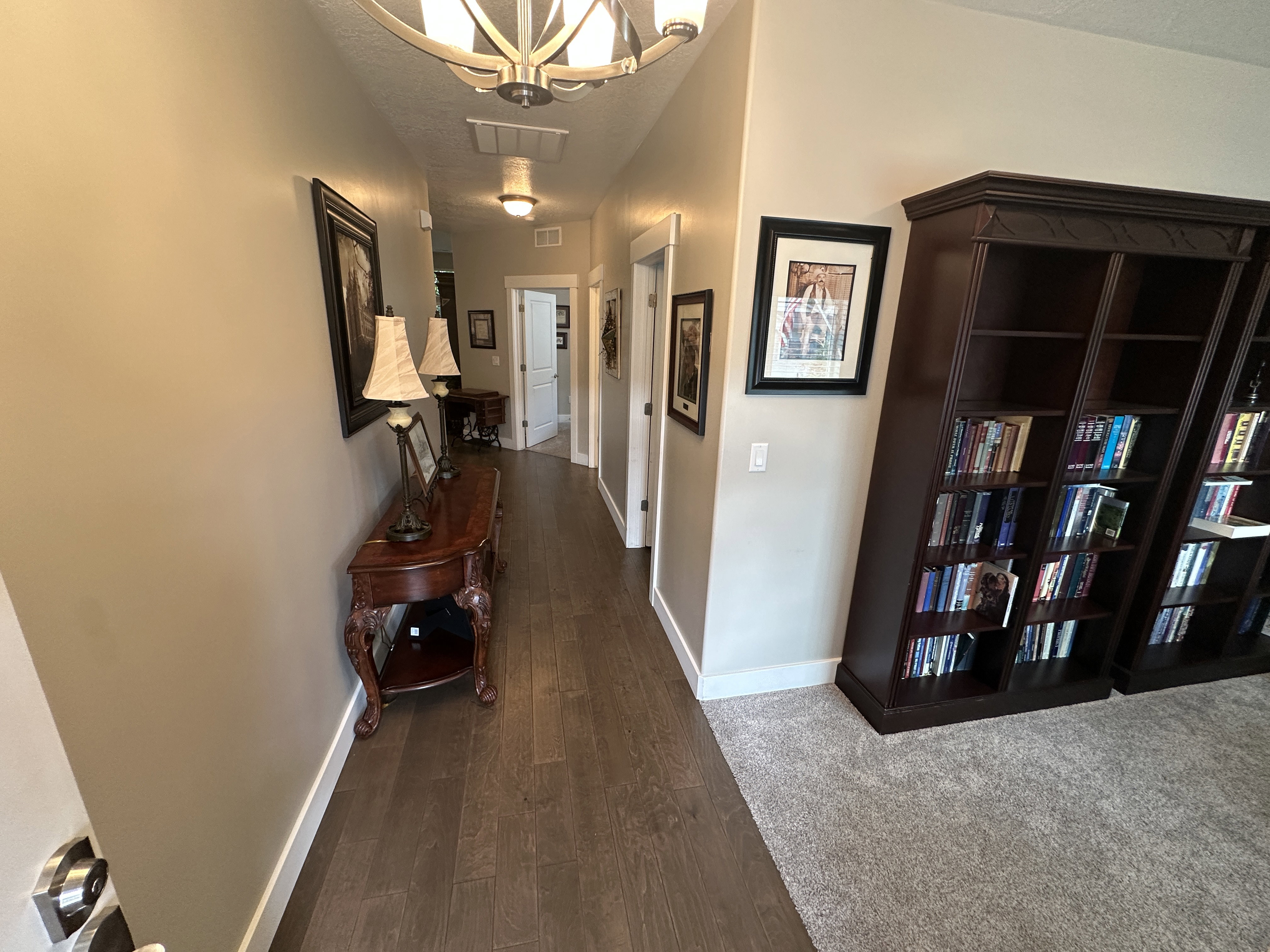 Hallway with wood-finish flooring, recessed lighting, and a decorative ceiling fixture