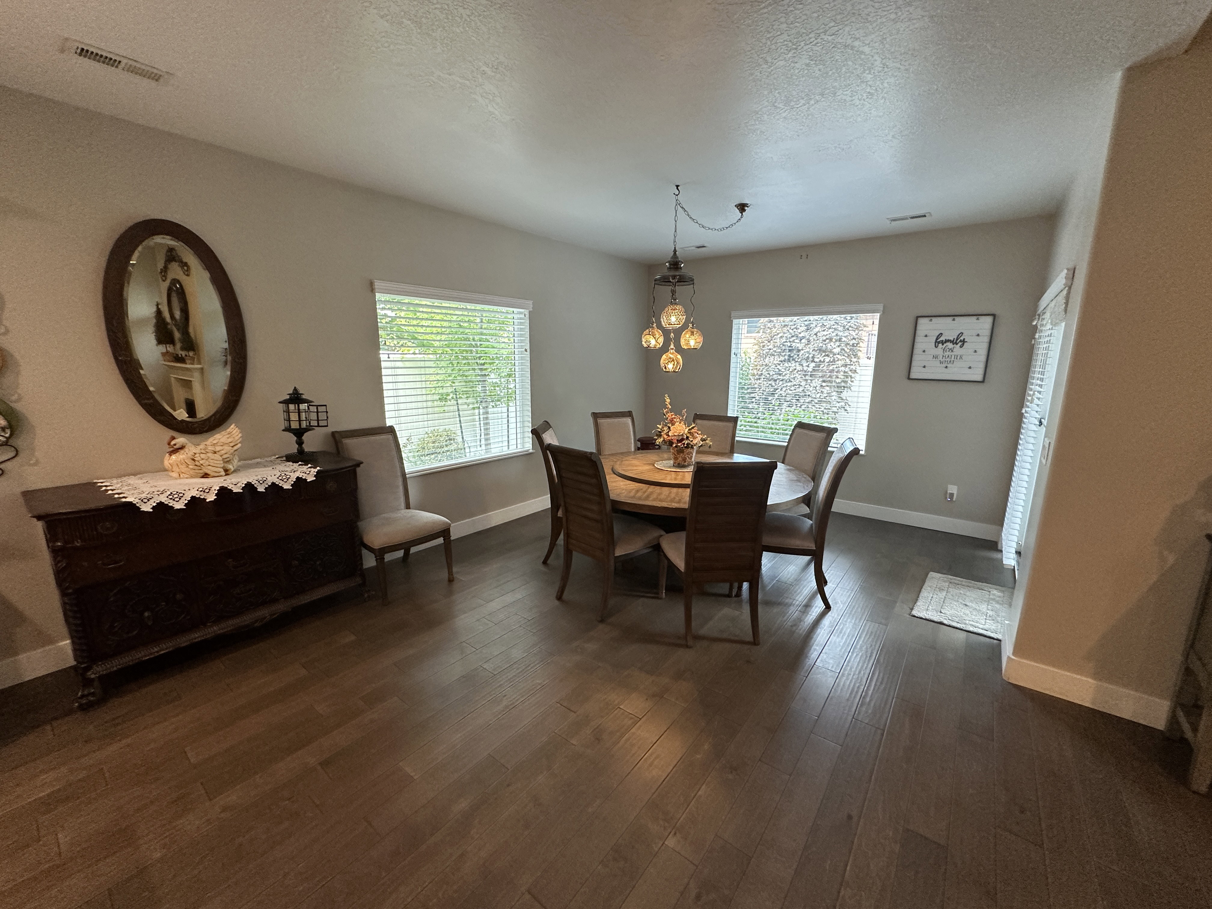 Spacious room featuring wood-finish flooring, two large windows with blinds, and recessed lighting