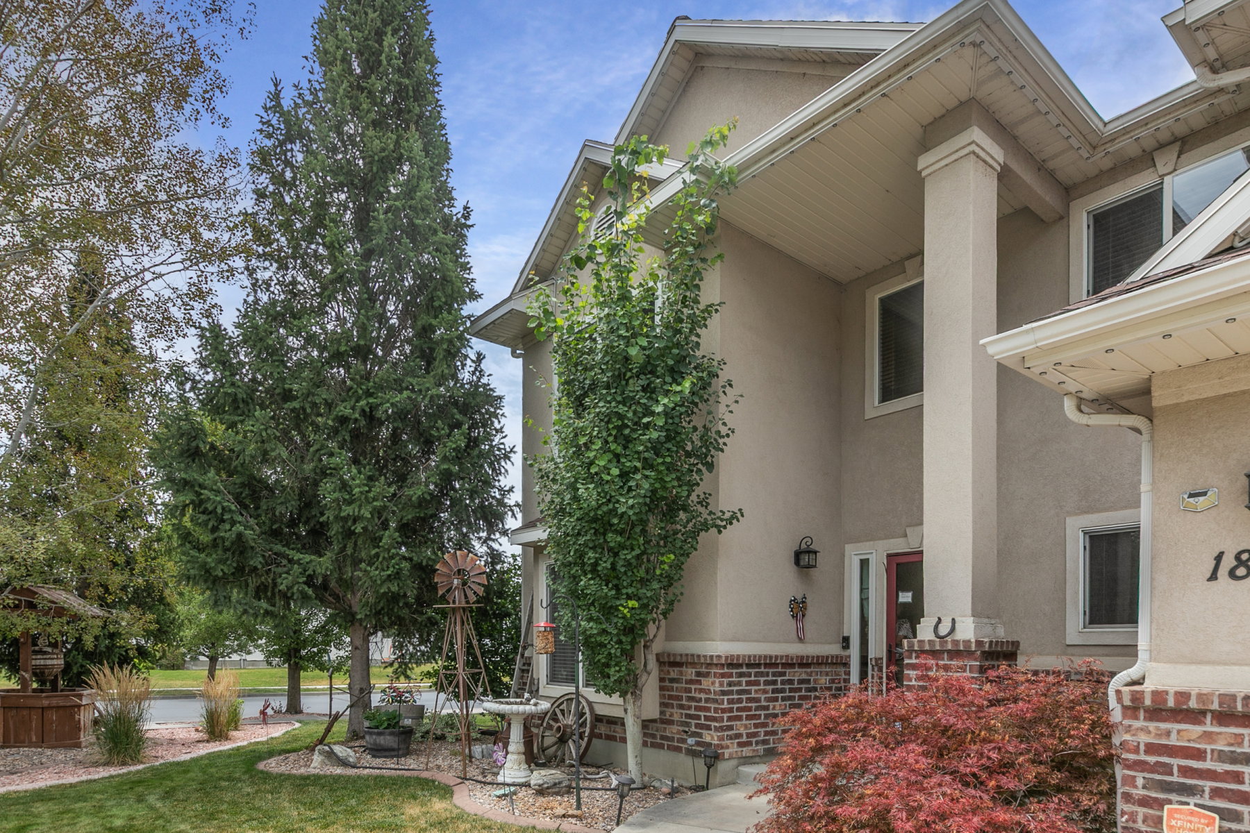 Stucco exterior with brick detailing, prominent entry columns, and a covered porch
