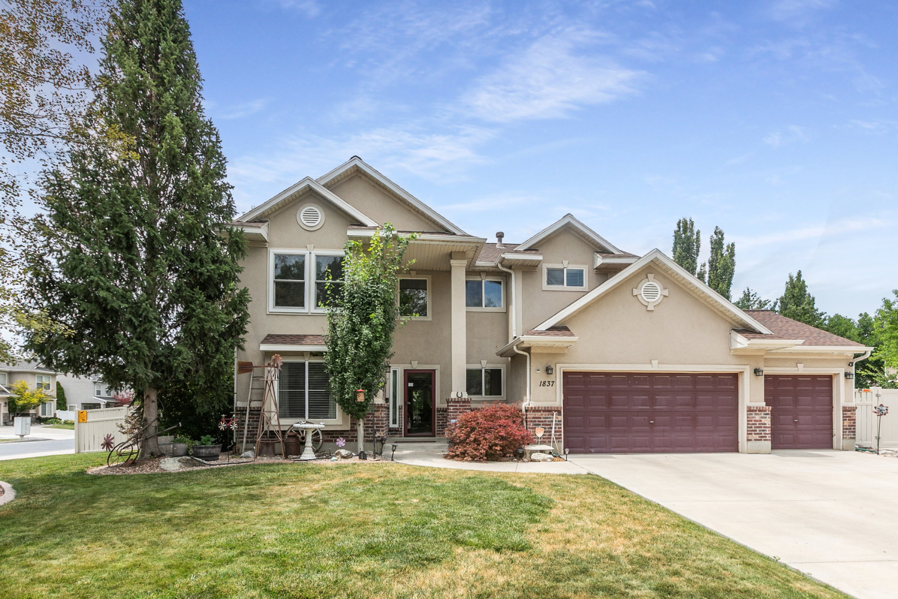 Stucco exterior with brick accents featuring multiple gables, and a three-car garage.