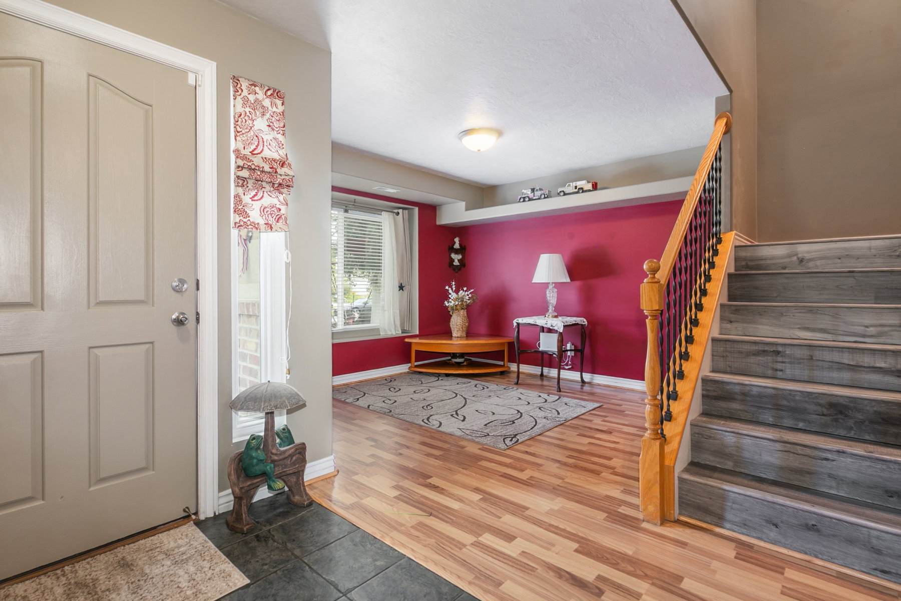 Entryway featuring a paneled door, slate tile stairs, and wood-finish flooring extending into the kitchen main living area