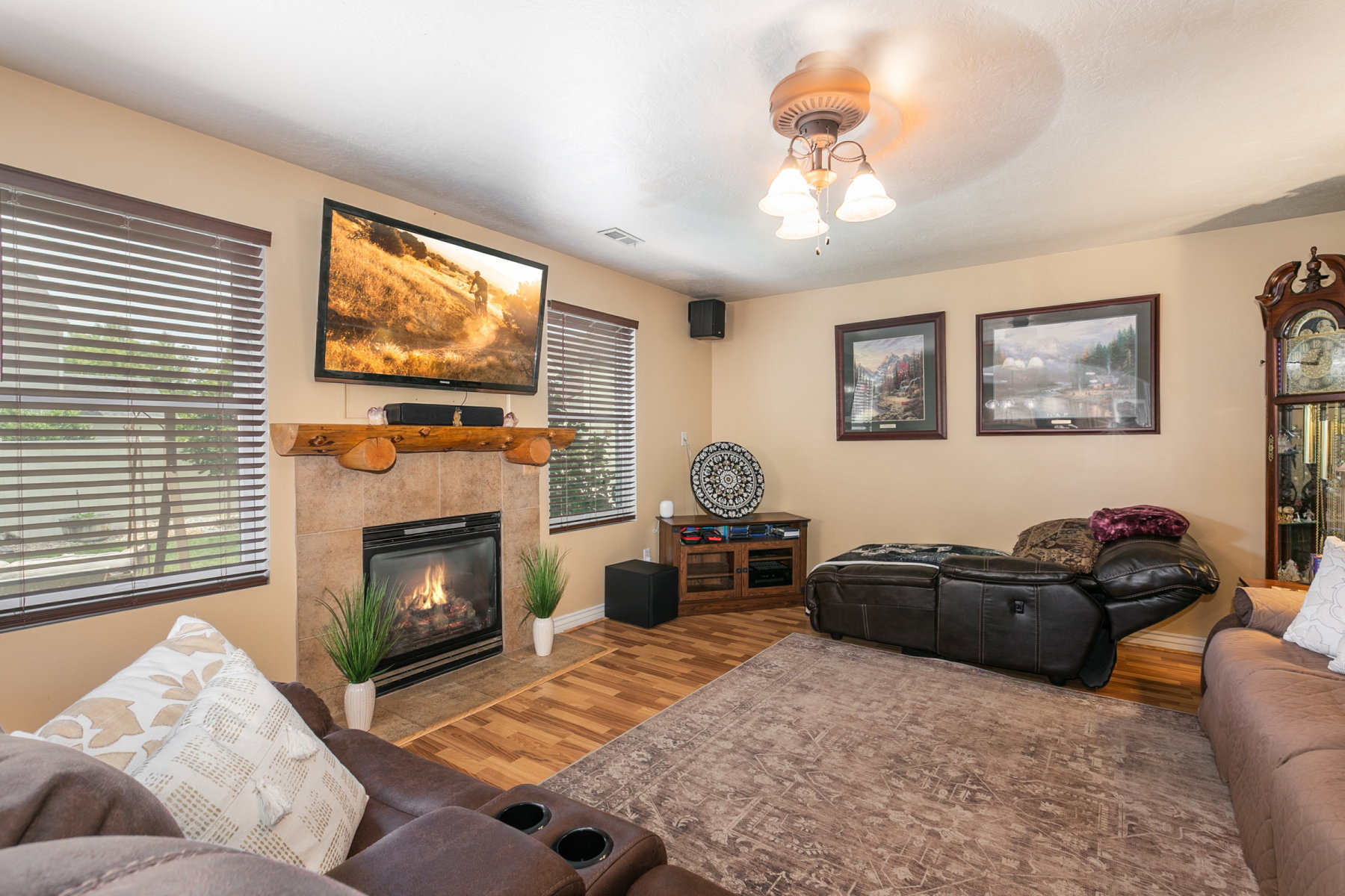 Living area featuring a gas fireplace with a rustic wood mantel, tile surround, and wood-finish flooring
