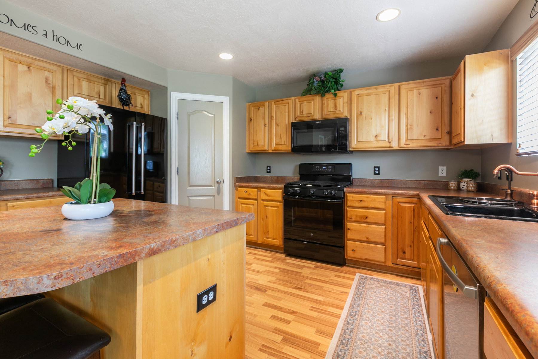Kitchen featuring wood-finish flooring, natural wood cabinetry,