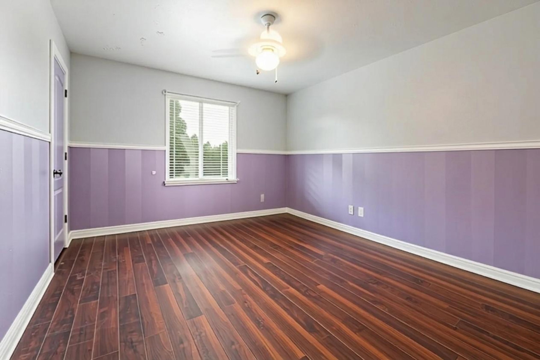 Room featuring wood-finish flooring, a ceiling fan with integrated lighting, and window with blinds