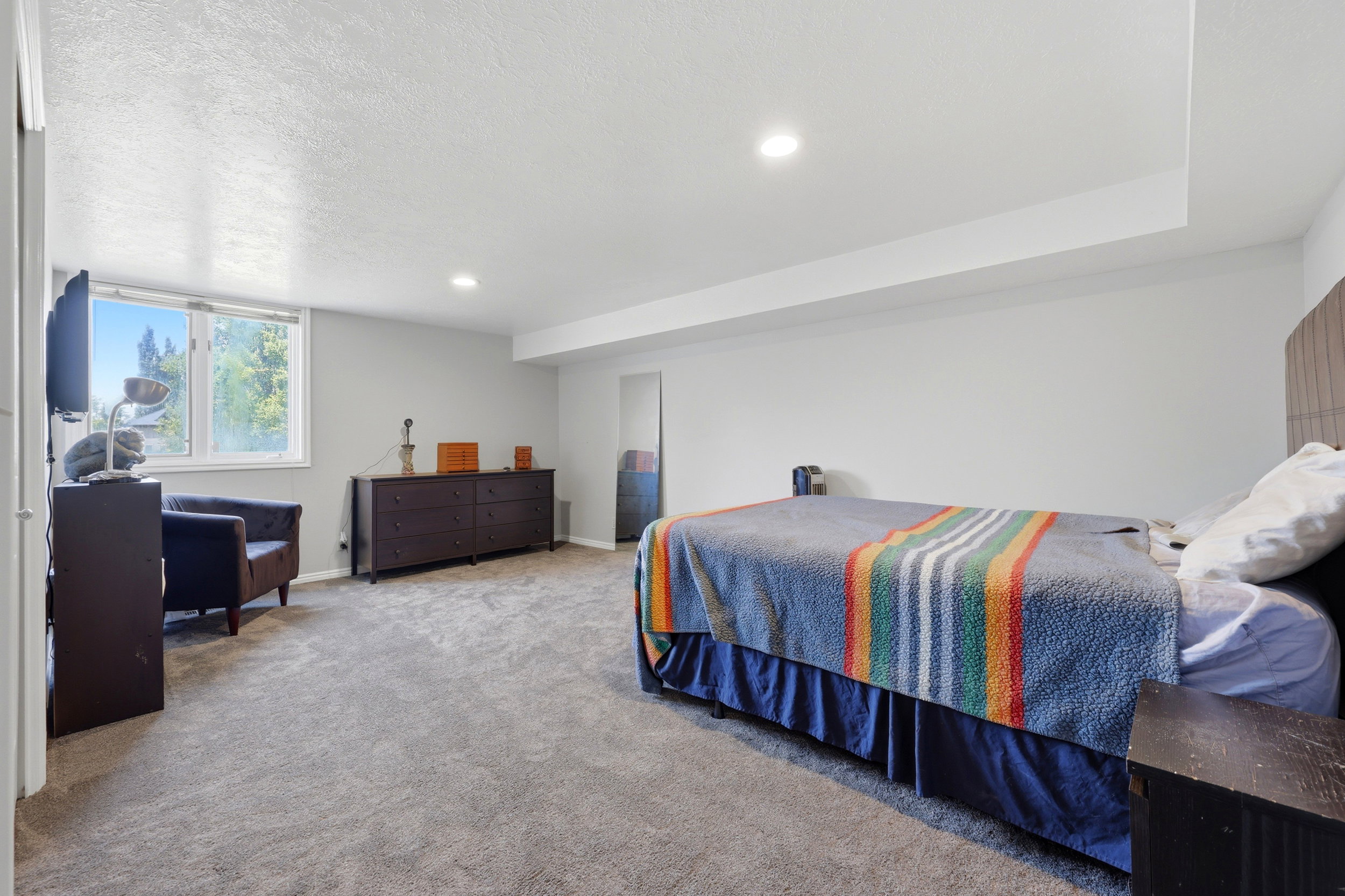 Carpeted room featuring recessed lighting and a large window