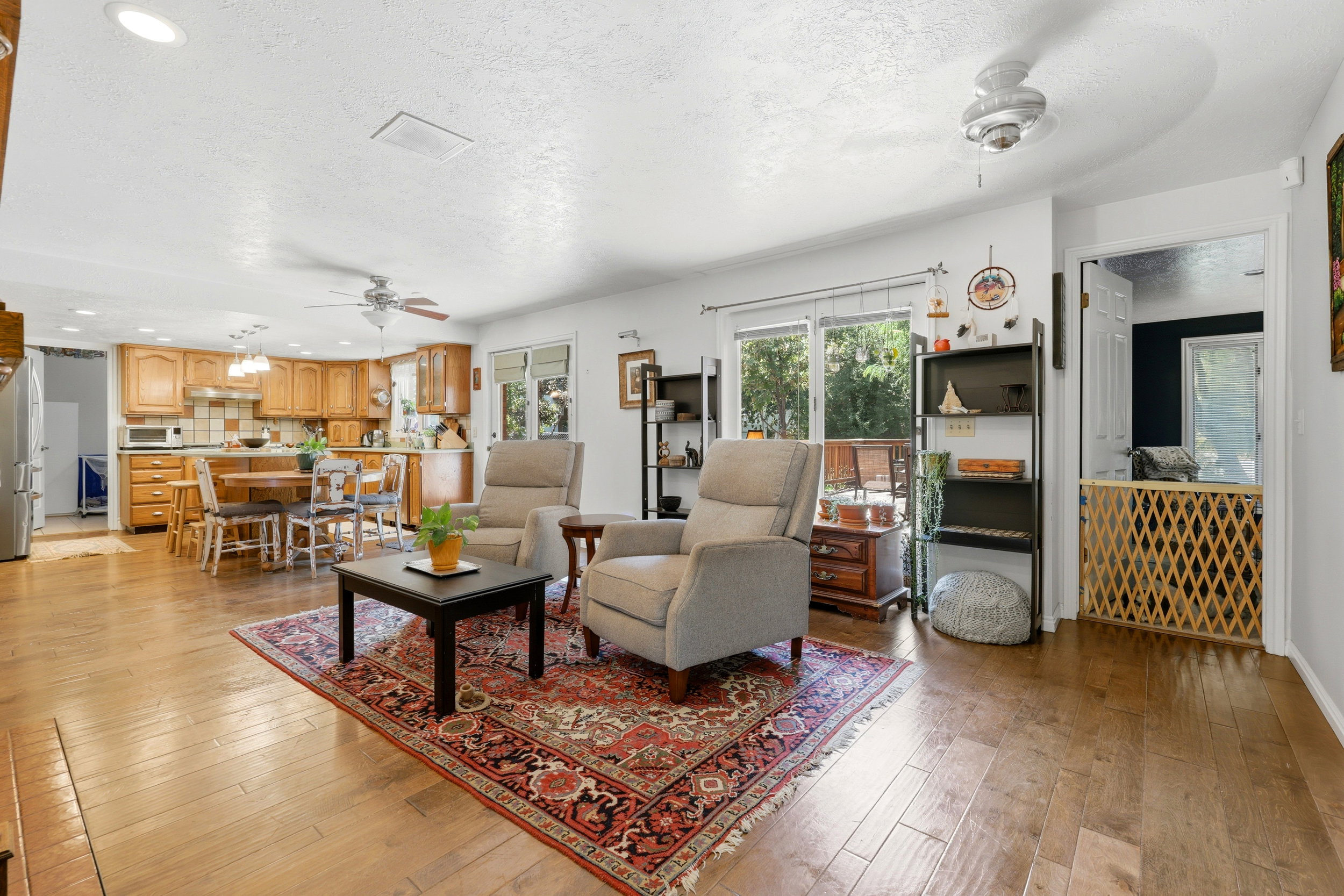 Open-concept living area featuring wood-finish flooring throughout, recessed lighting, and ceiling fans