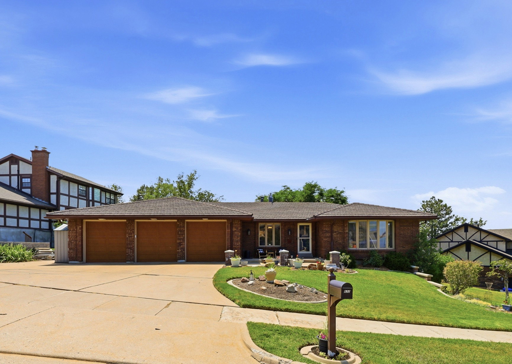 Brick exterior featuring a three-car garage, bay window, and a gabled roof