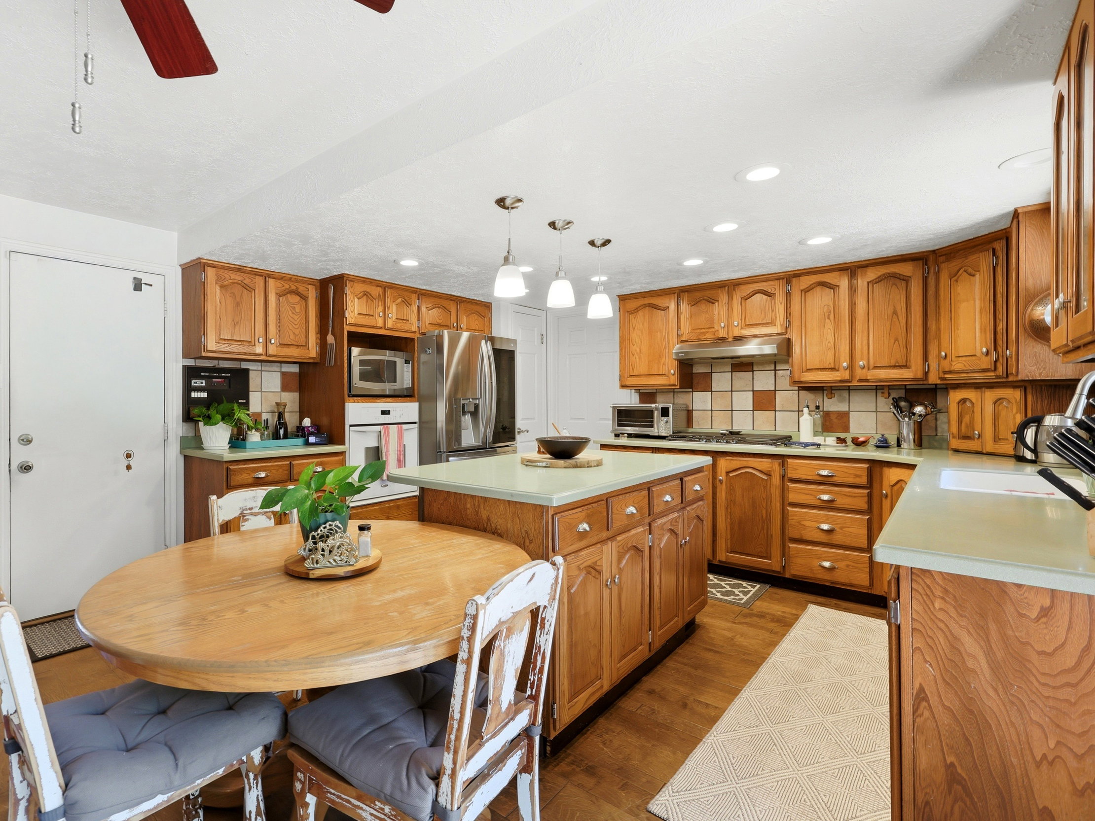 Kitchen featuring wood-finish cabinetry, stainless steel appliances, recessed lighting, and a central island with pendant lighting