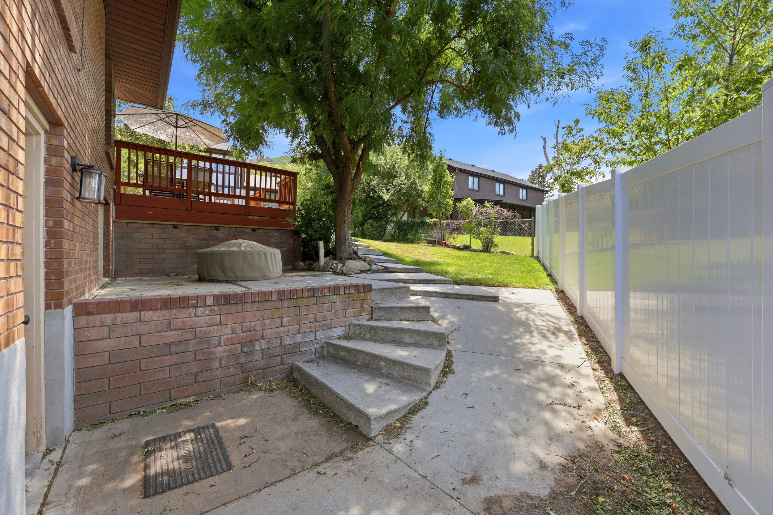 Brick exterior with a raised wooden deck featuring a railing