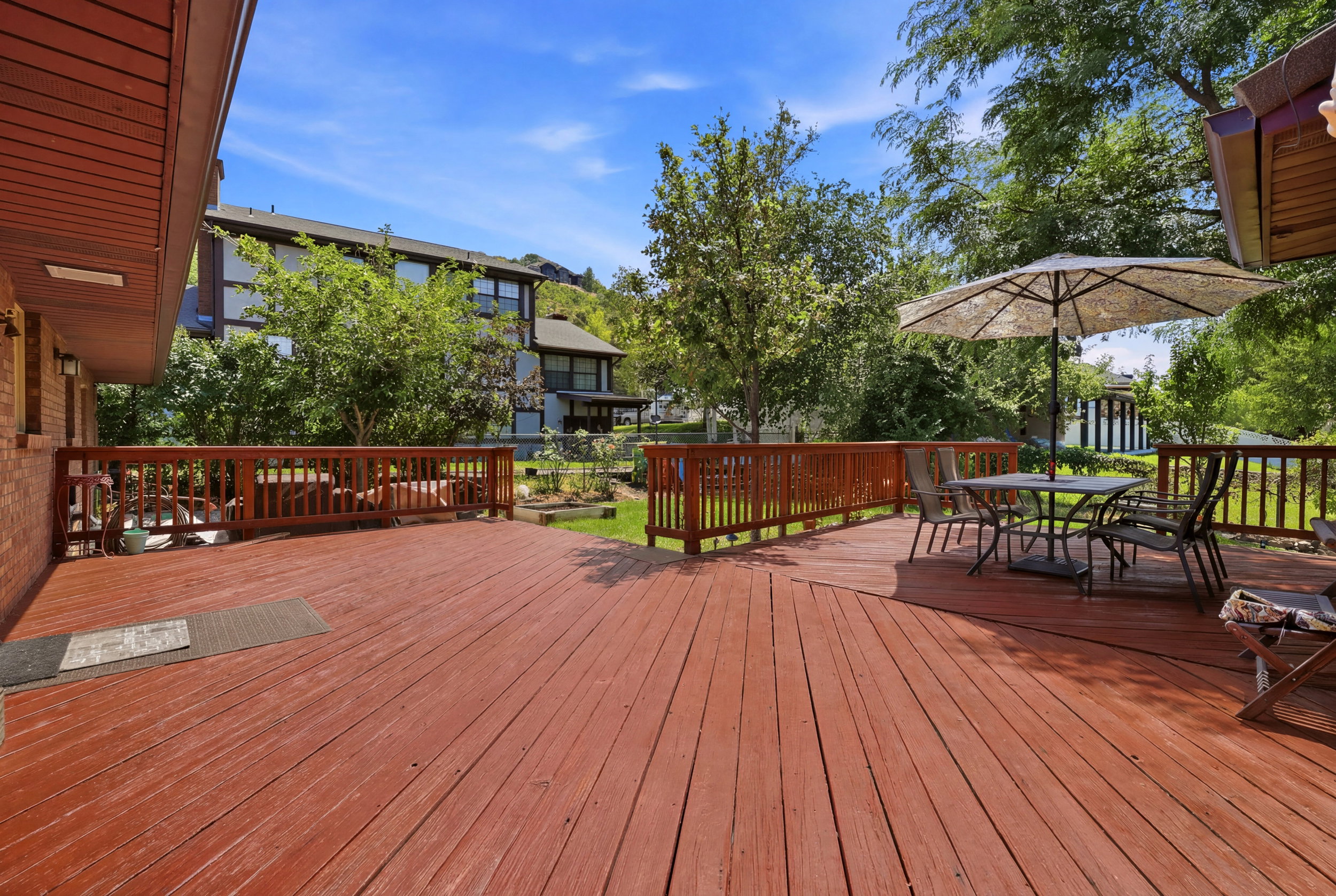 Wood-finish deck with perimeter railings, featuring multiple distinct areas
