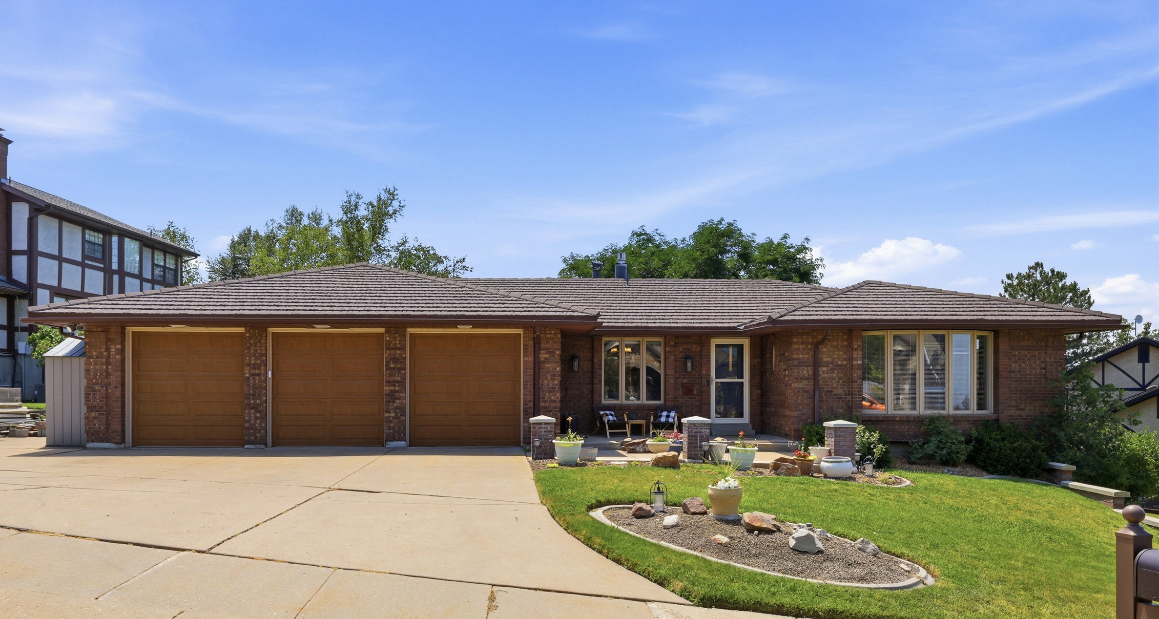 Brick exterior with a three-car garage and a concrete driveway