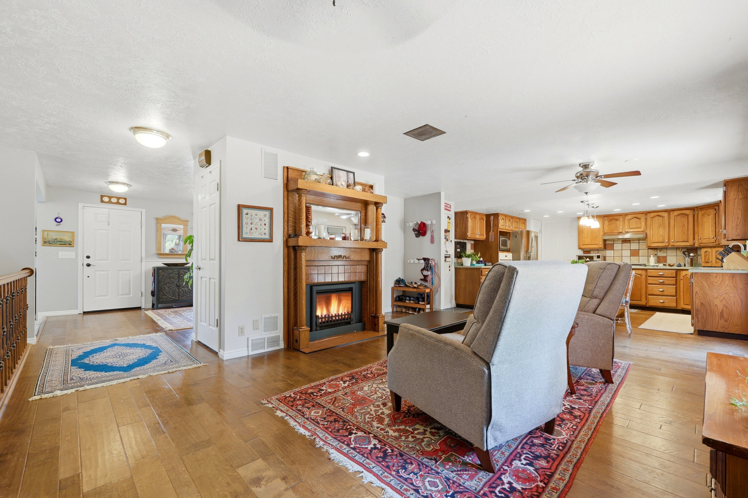 Living area featuring a prominent wood-mantled fireplace with a brick surround