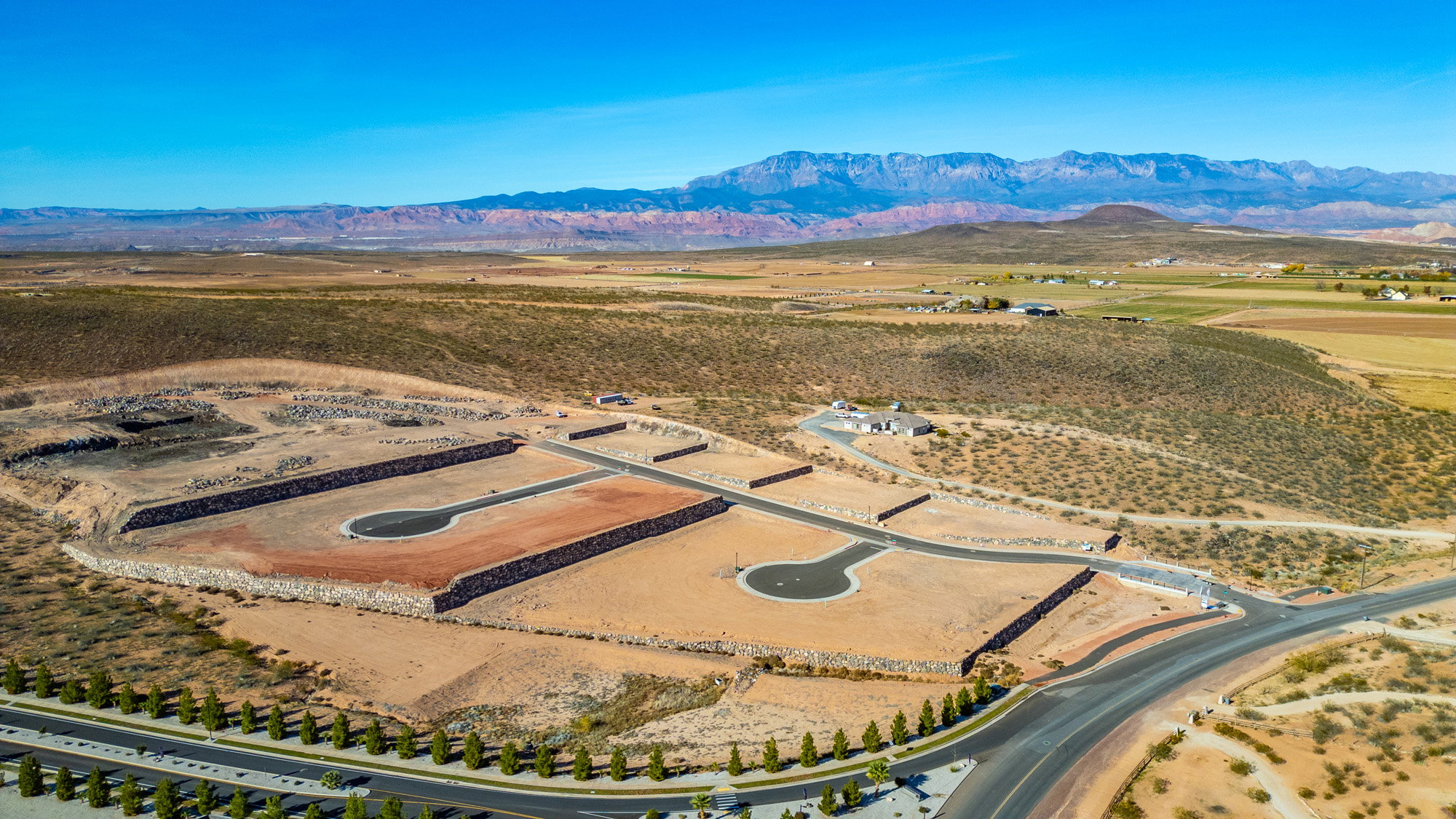 Developed land featuring multiple graded building pads, paved roads, and cul-de-sacs