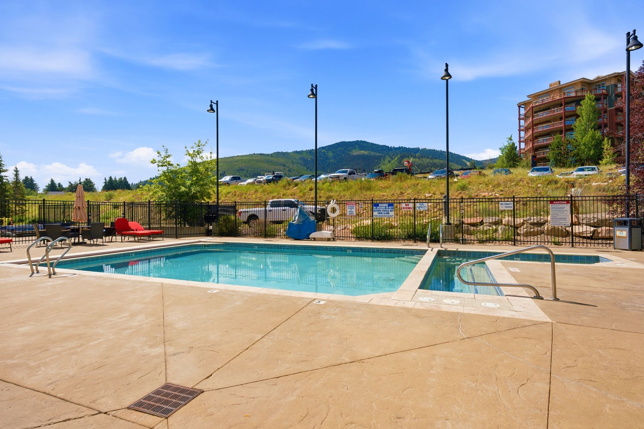 Outdoor swimming pool and hot tub with textured concrete decking