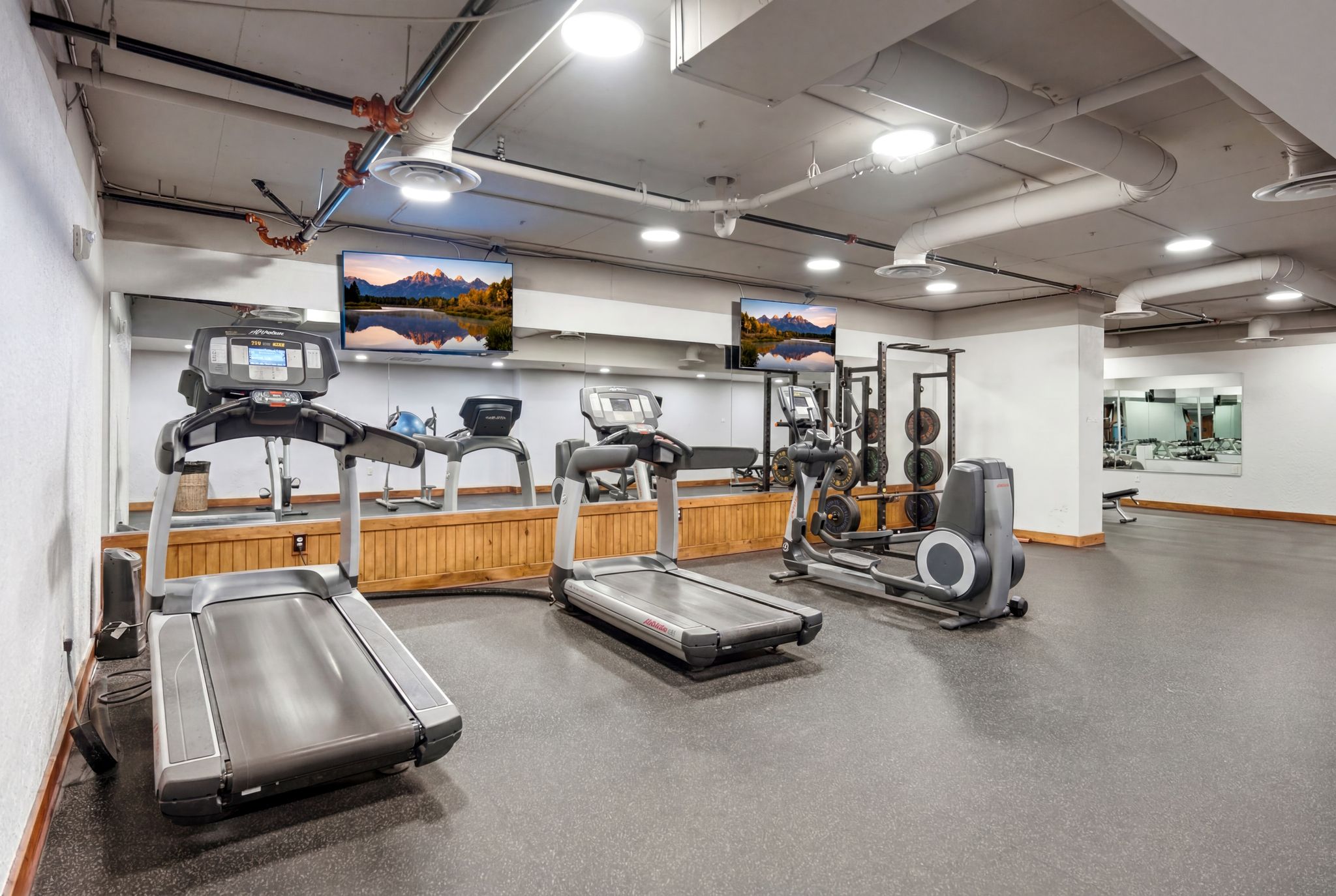 Fitness room featuring dark rubber flooring and exposed overhead ductwork