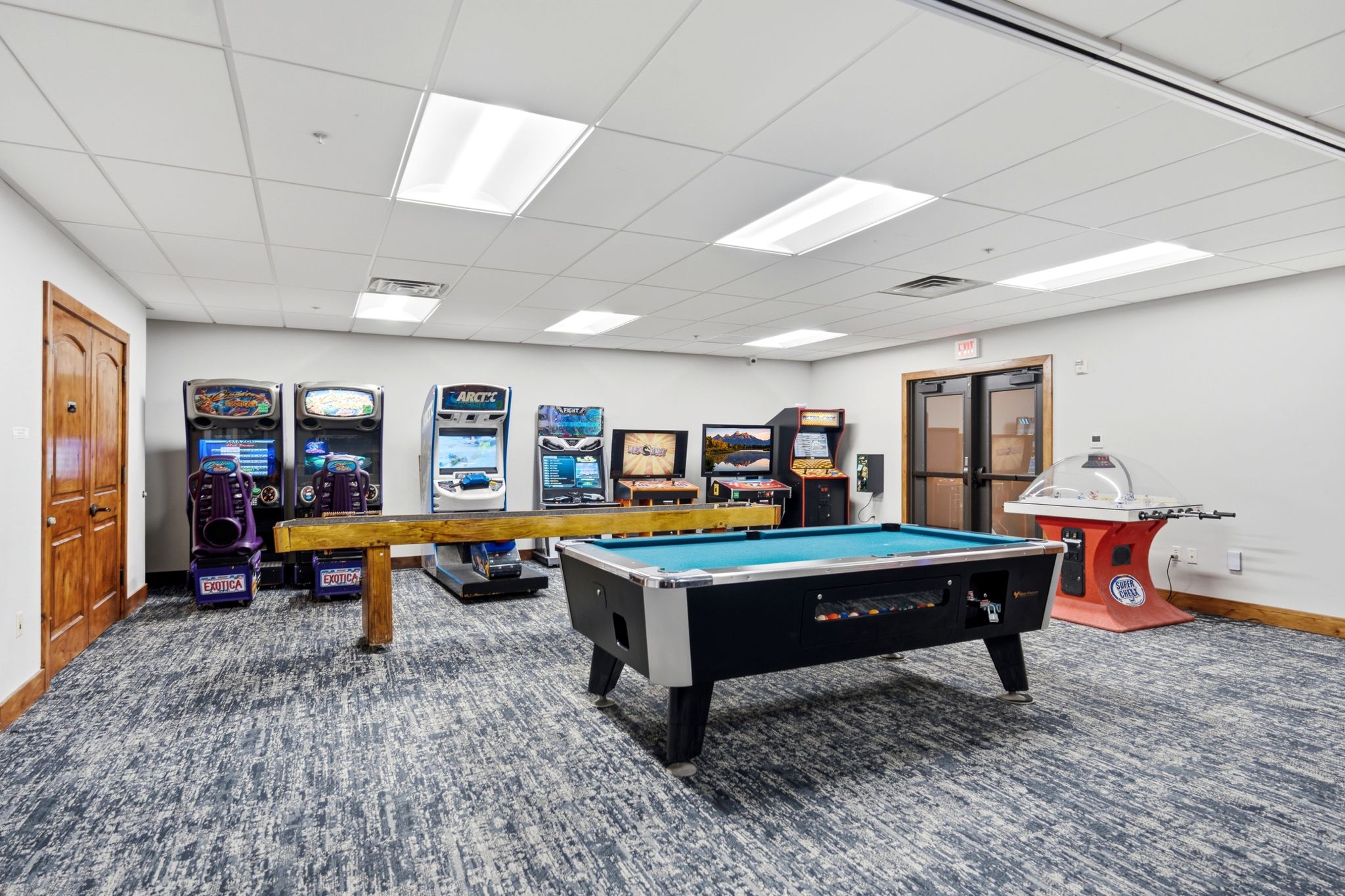 Spacious recreational area featuring a pool table, gray patterned carpeting, white walls, and a dropped ceiling with recessed lighting