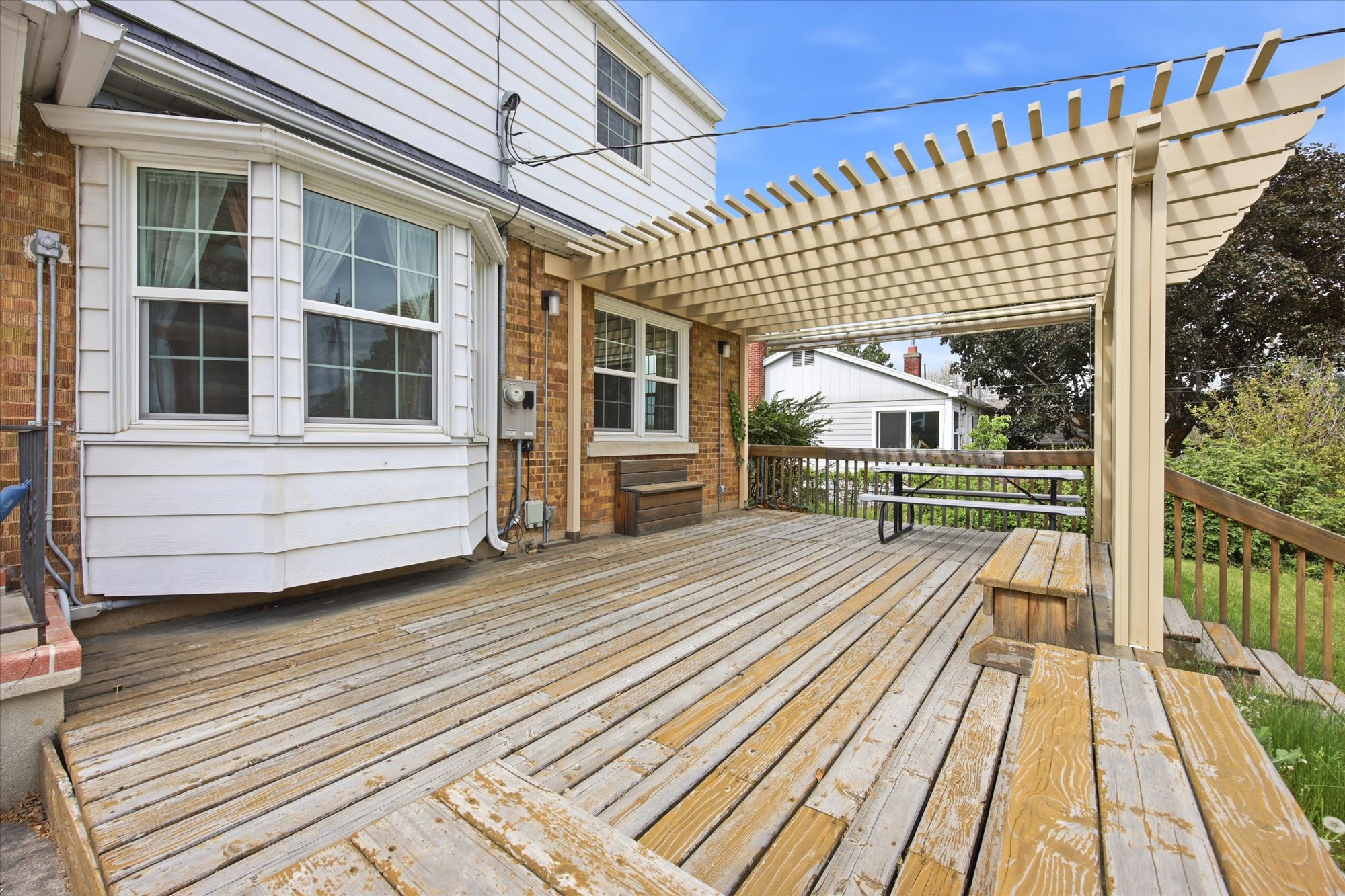 Wood-finish deck with a pergola covering a portion of the area