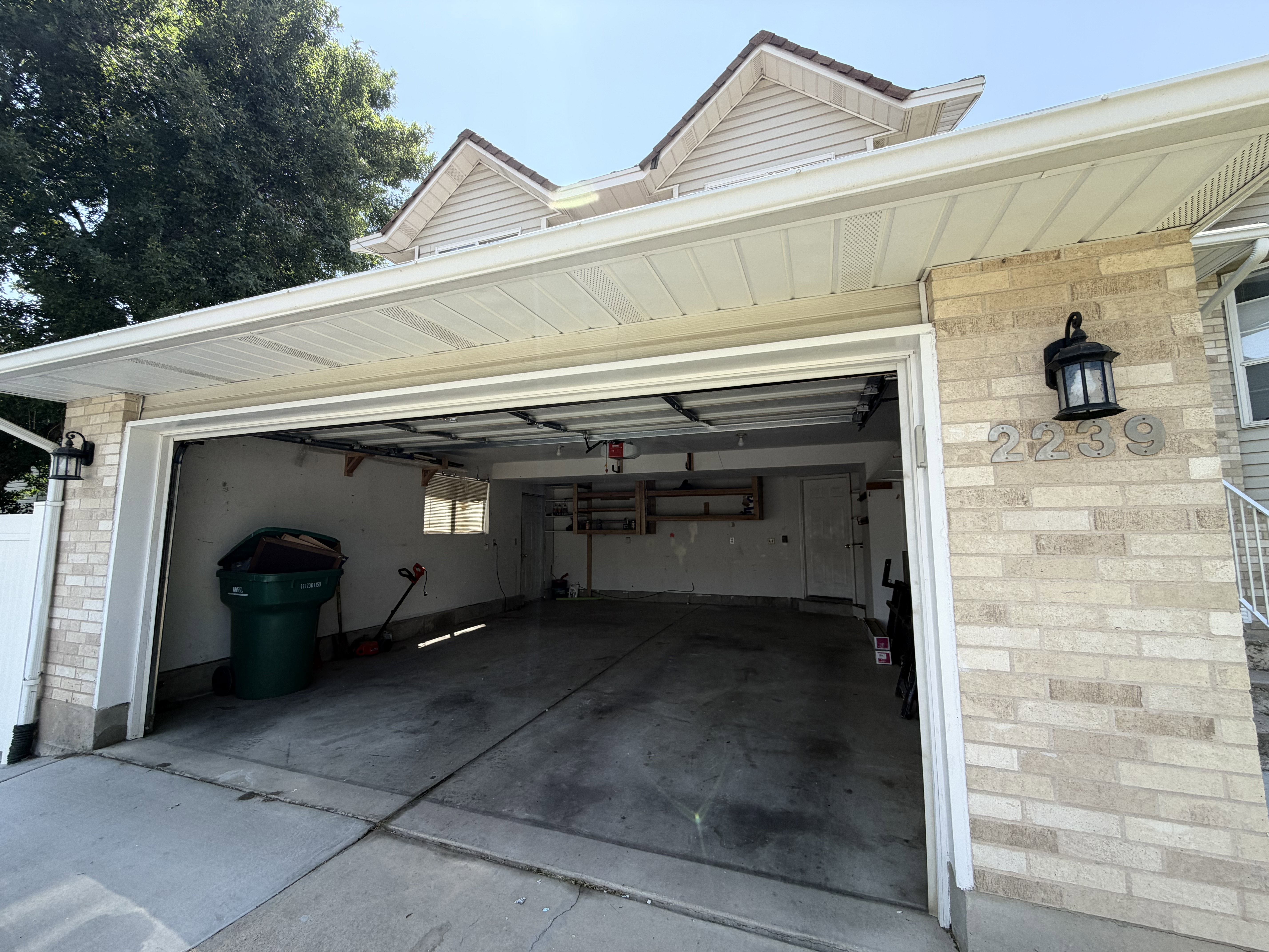 Two-car garage with concrete flooring and built-in shelving