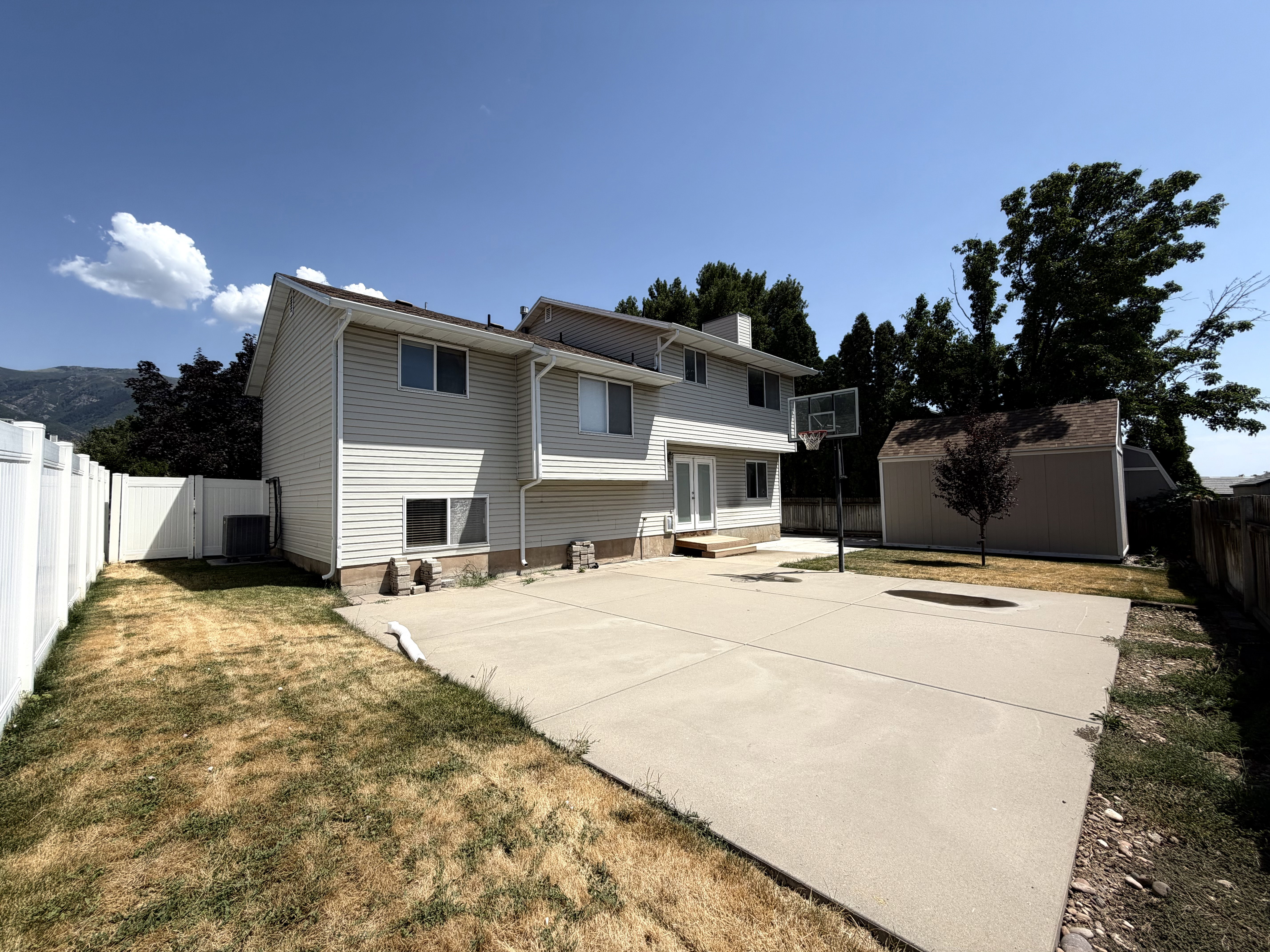 Rear exterior of a two-story residence featuring light-colored siding