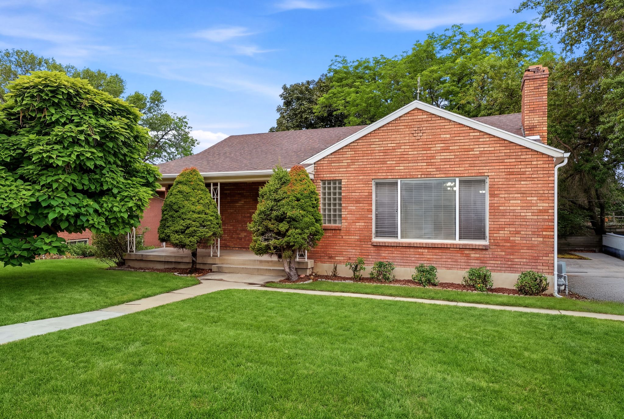 Brick exterior featuring a gabled roof and prominent chimney
