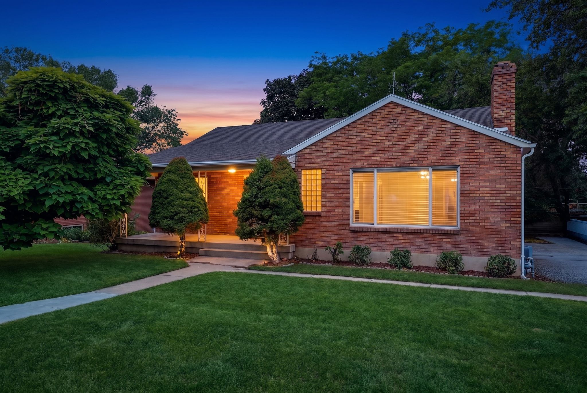 Brick exterior with a prominent chimney and a paved driveway
