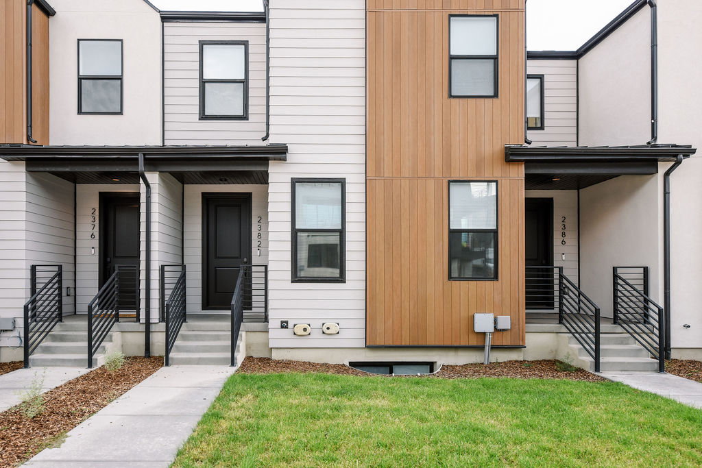 Modern townhome exterior featuring contemporary vertical wood-look siding and light-colored horizontal siding