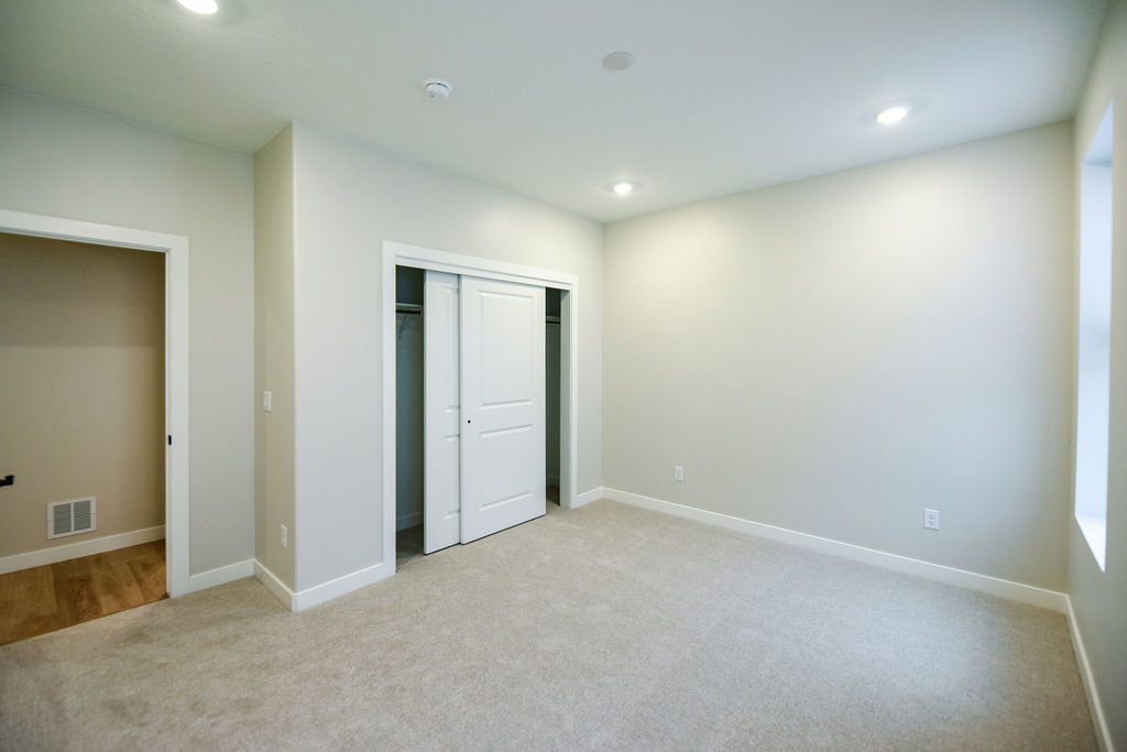 Carpeted room featuring recessed lighting, a window, and a sliding closet door