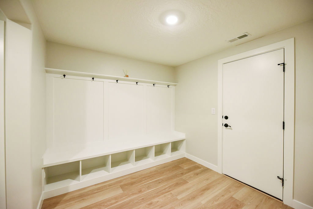 Built-in mudroom bench with cubby storage and black coat hooks