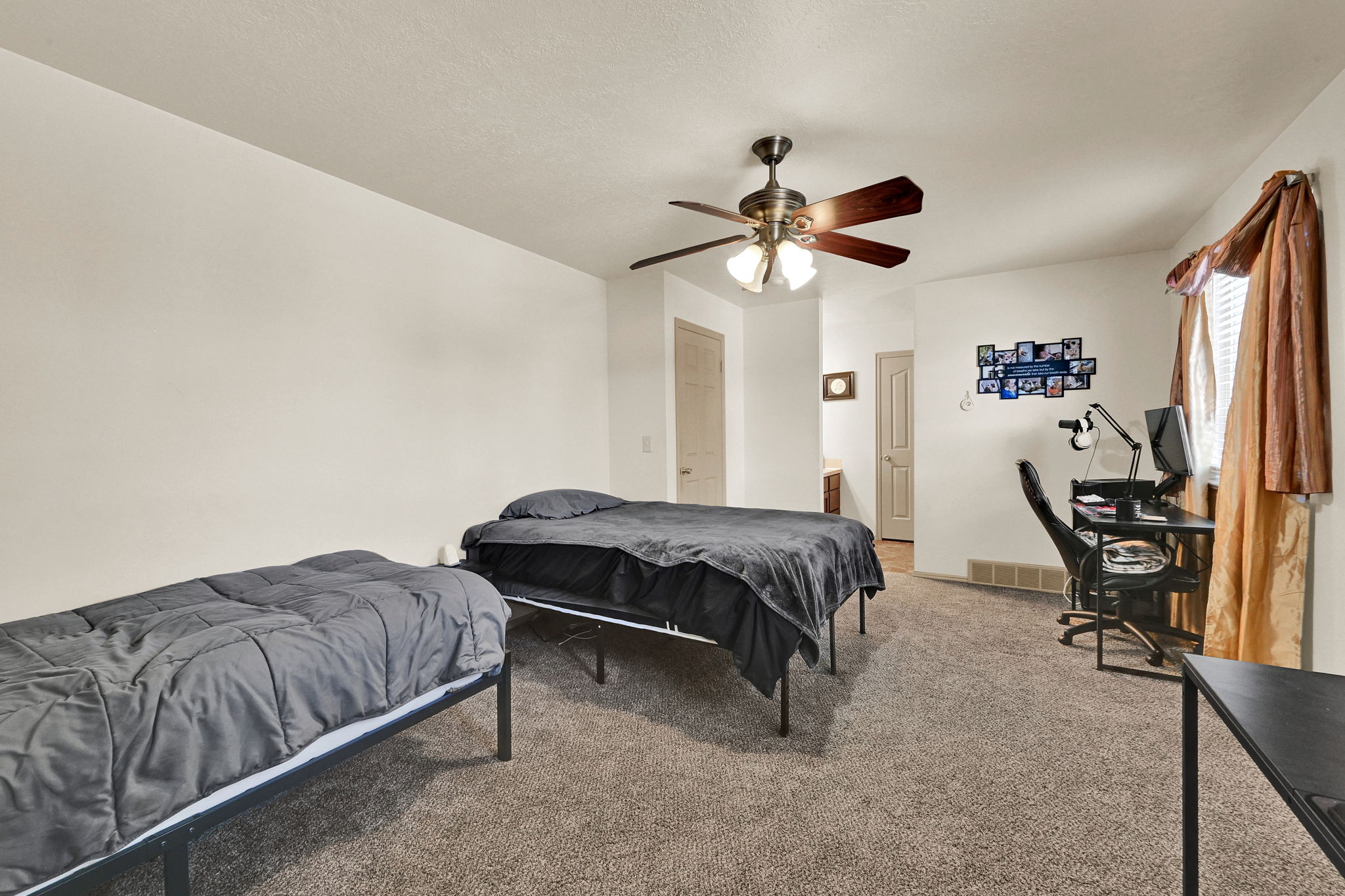 Spacious interior room featuring light-colored walls and neutral carpeting