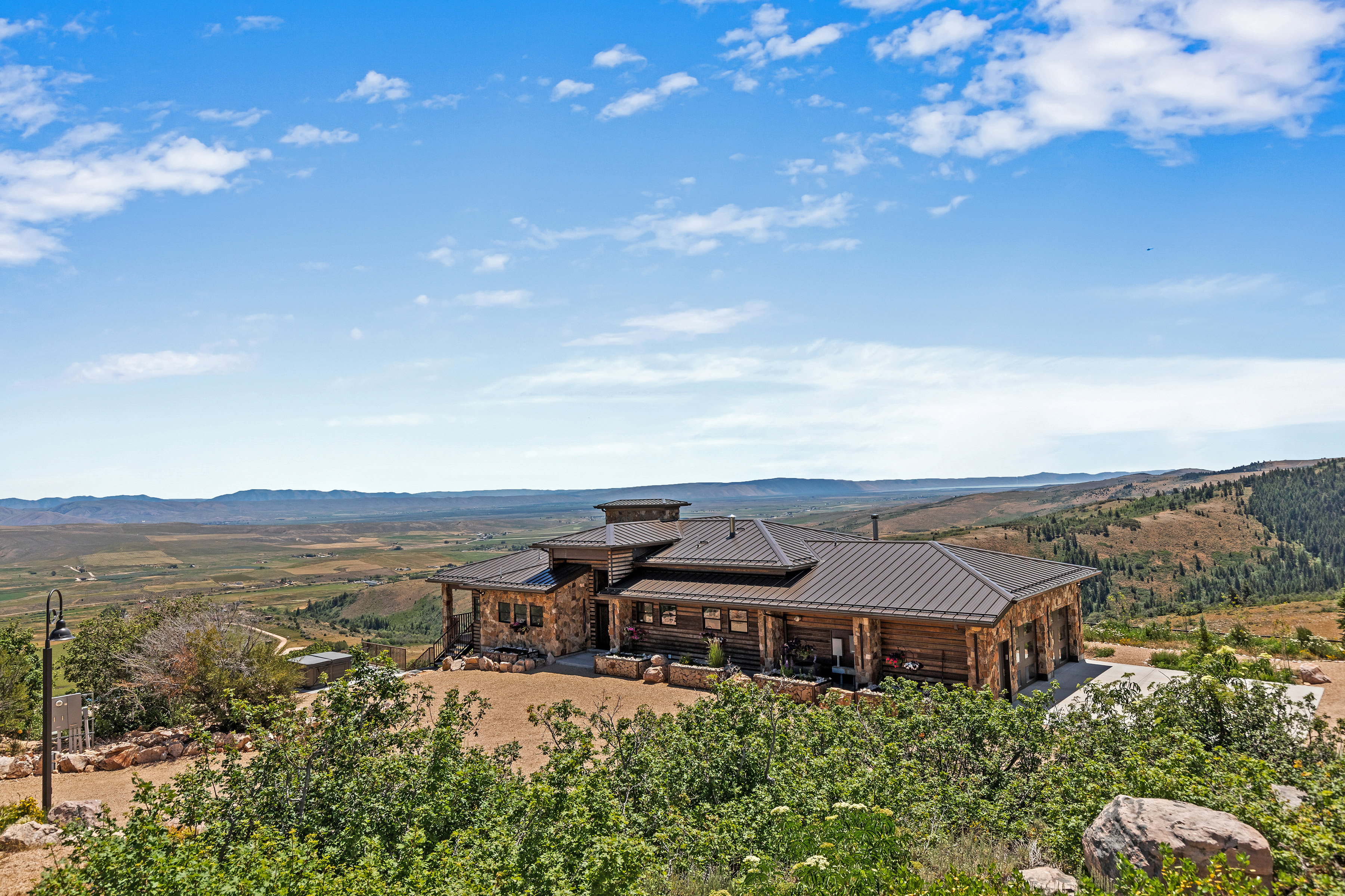 Expansive log and stone residence featuring a multi-gabled metal roof