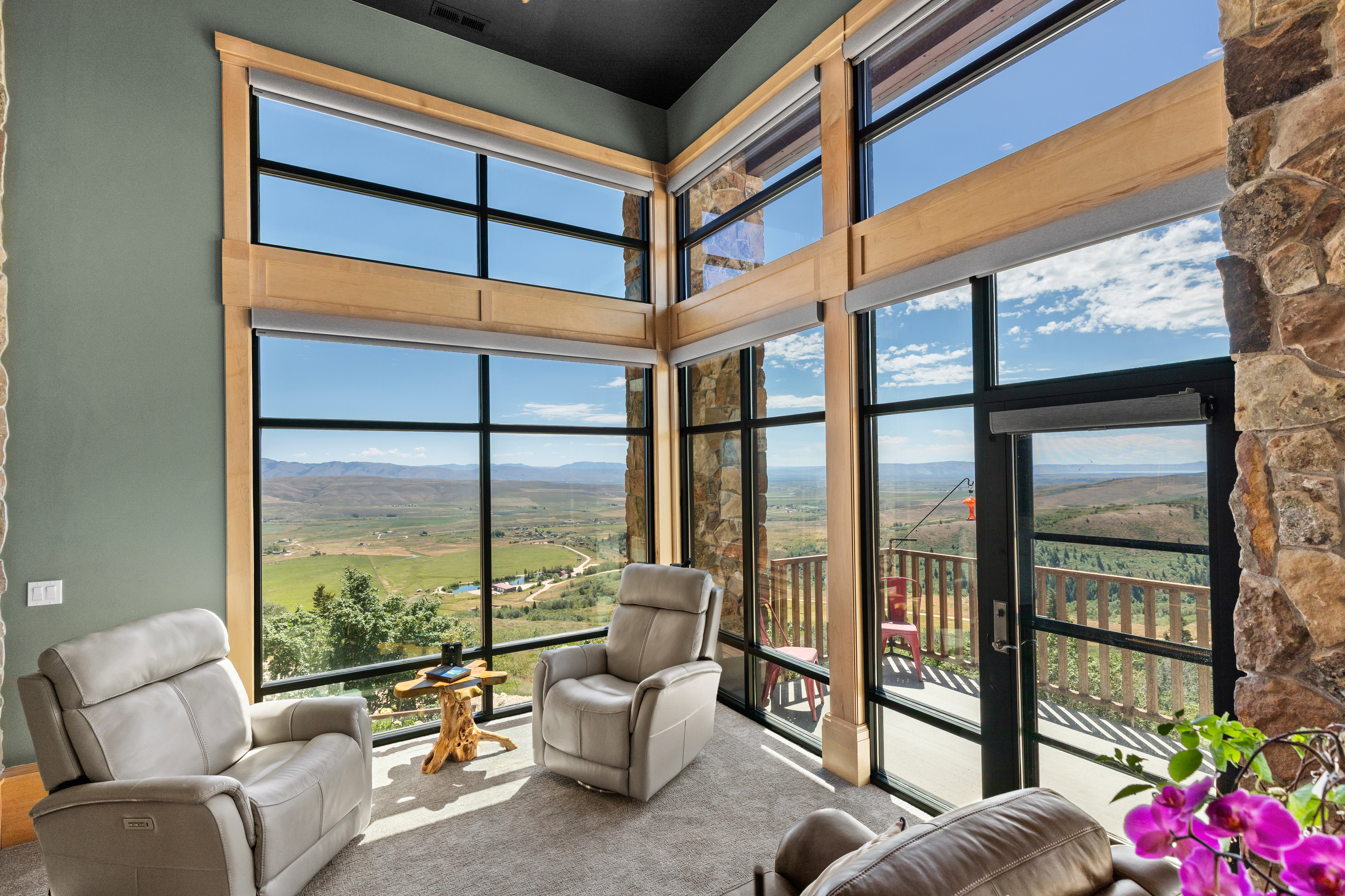 Two-story windows featuring wood framing and roller shades