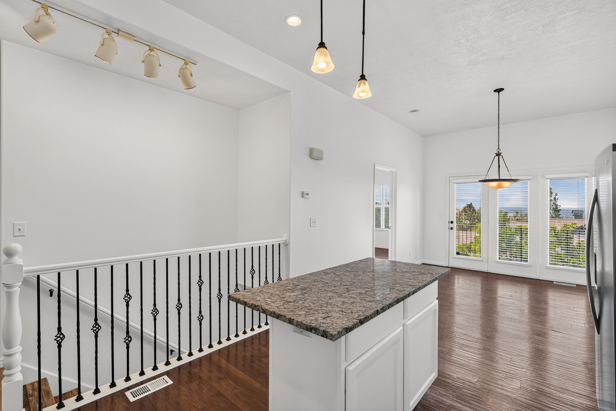 Kitchen island with a granite countertop and white cabinetry