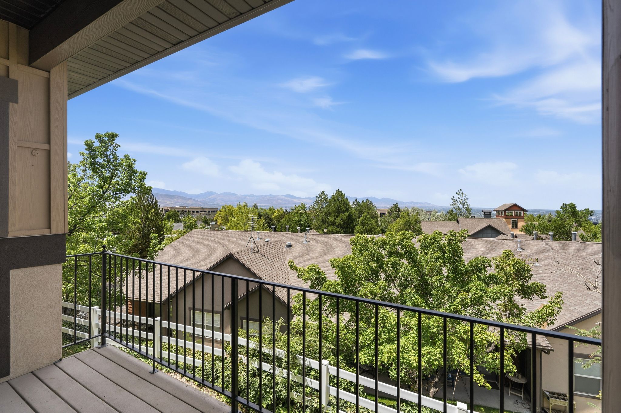 Private balcony featuring composite decking and a black metal railing