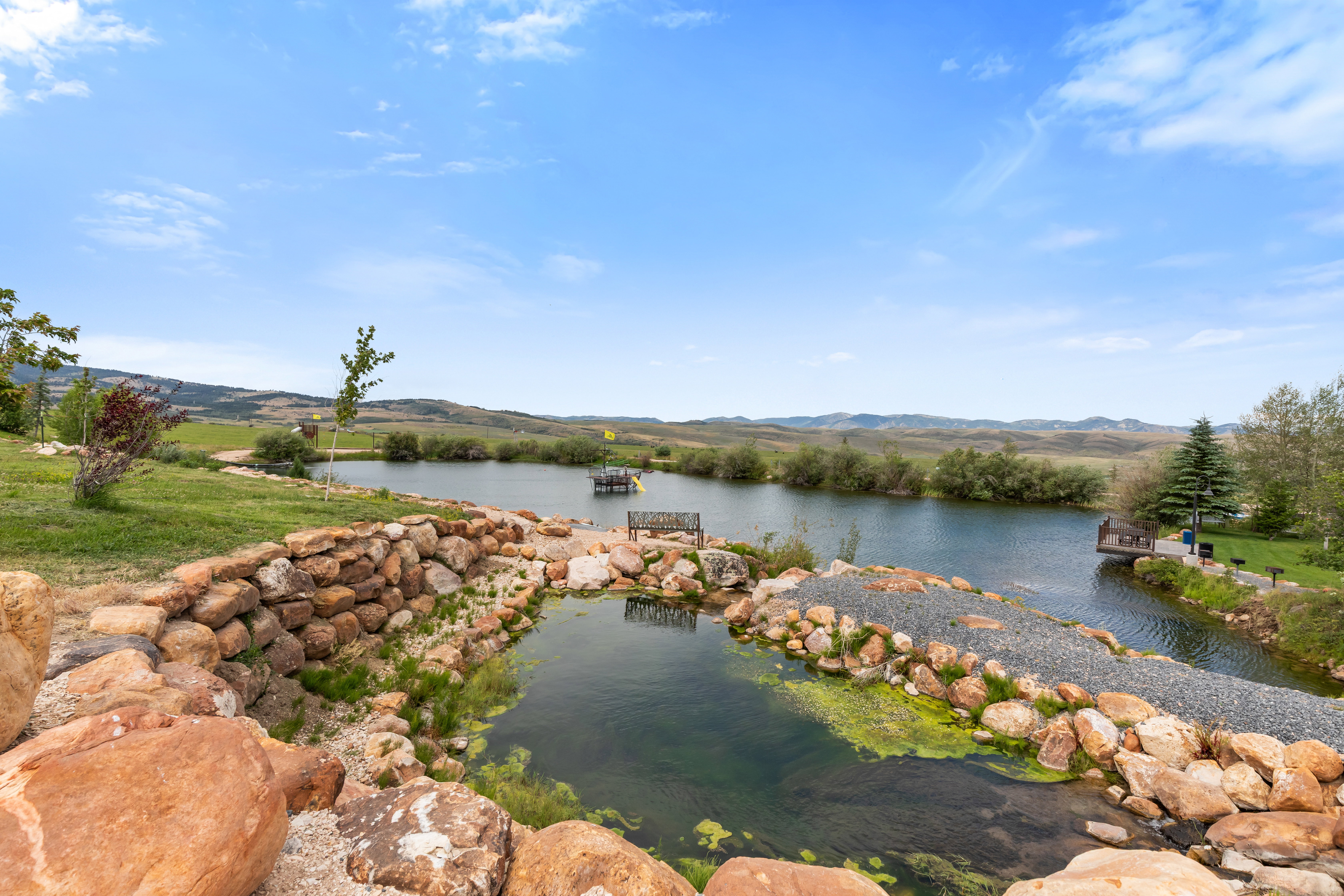 Pond feature with rock landscaping and gravel pathway
