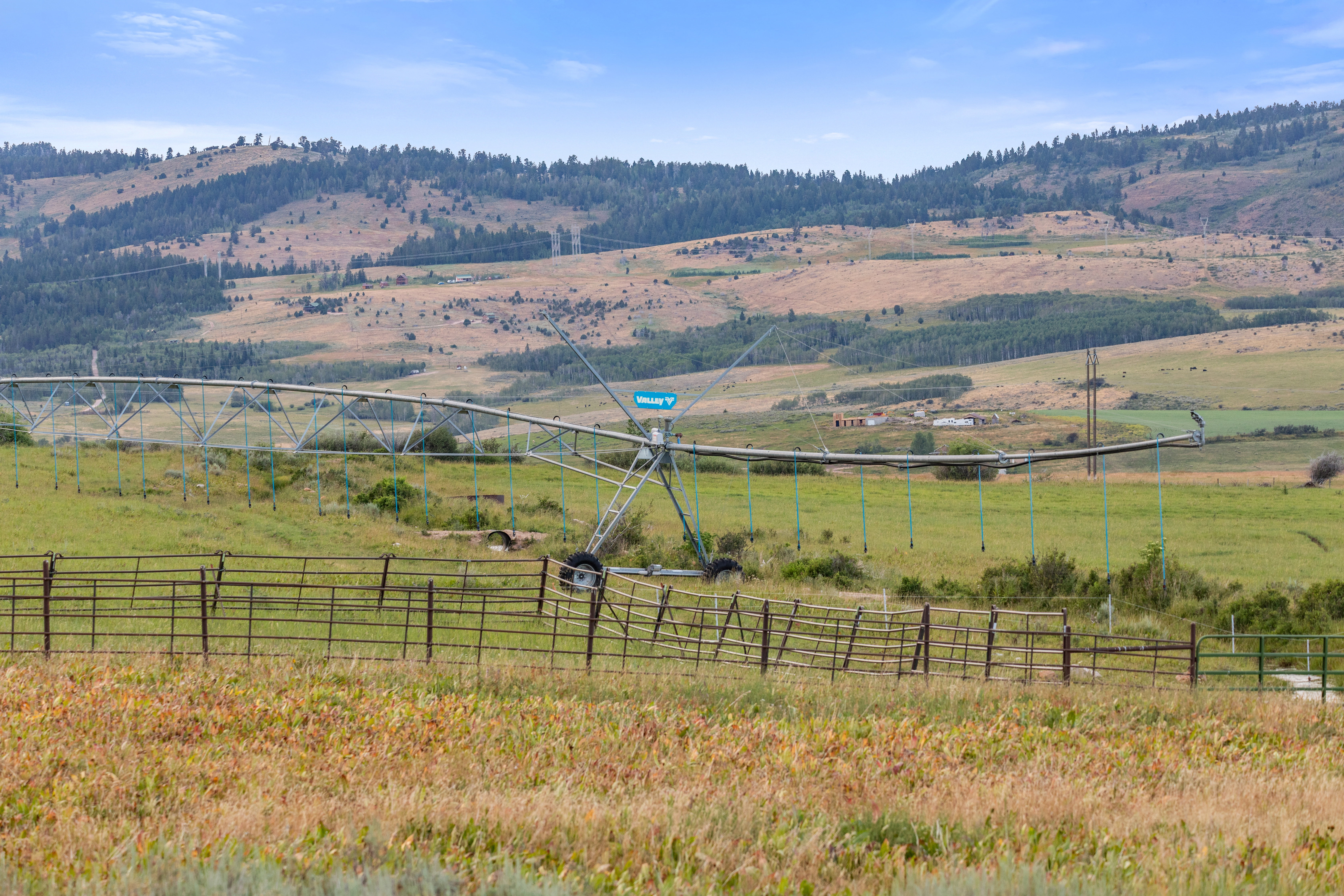 Expansive agricultural land featuring a center pivot irrigation system and perimeter fencing