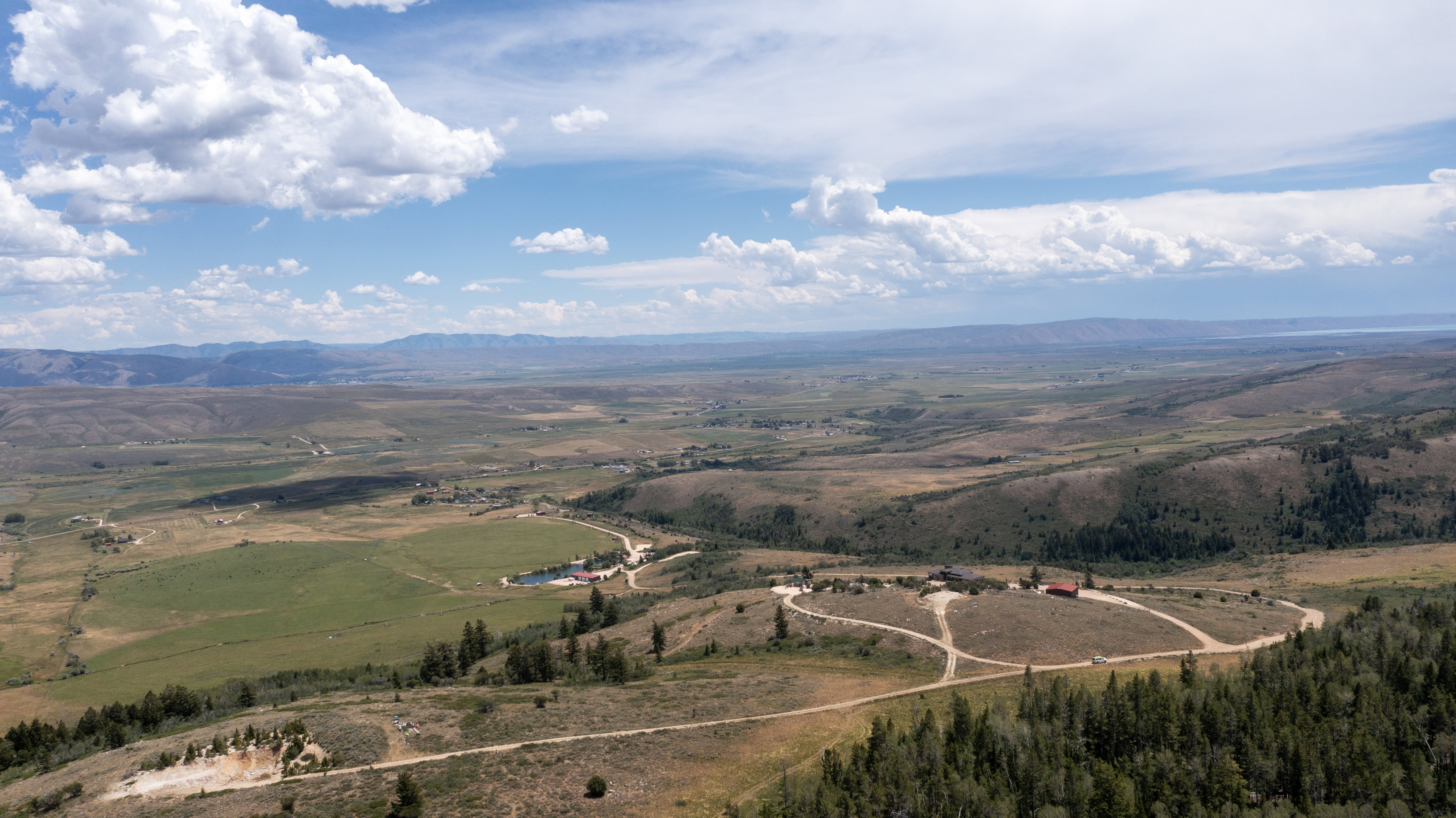 Expansive aerial perspective showcasing a vast landscape with rolling hills and distant mountains